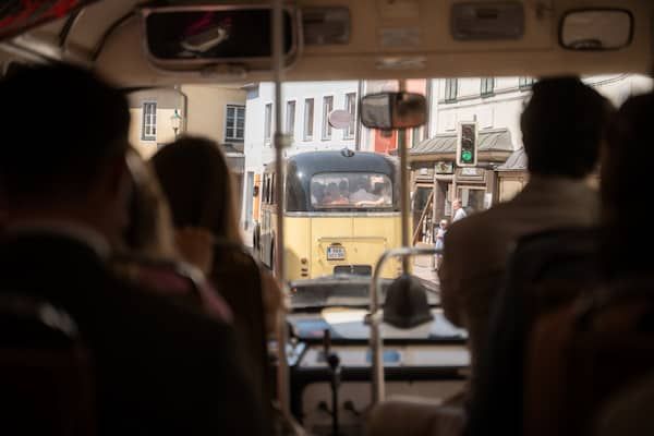 Perspektive aus einem Oldtimerbus auf den vorausfahrenden Oldtimerbus.