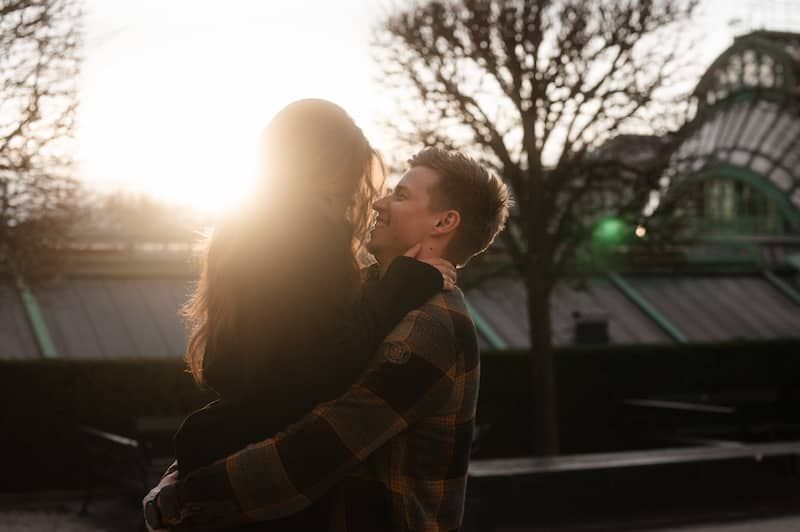 Anna & Martin – Martin hebt Anna hoch, sie lächeln sich an. Die Sonne geht gerade unter