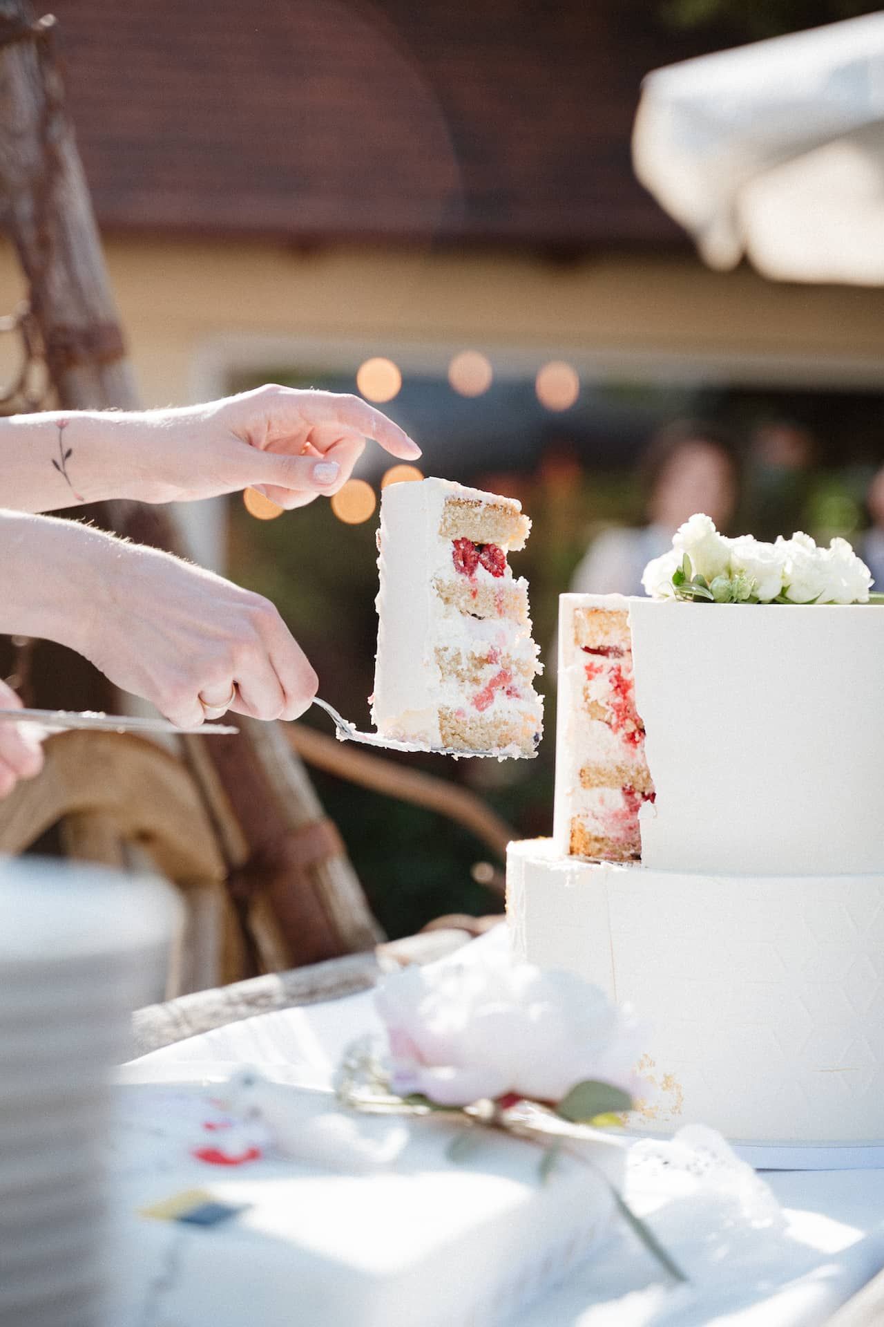 Closeup von einem Stück Hochzeitstorte, das mit dem Tortenheber herausgehoben wird