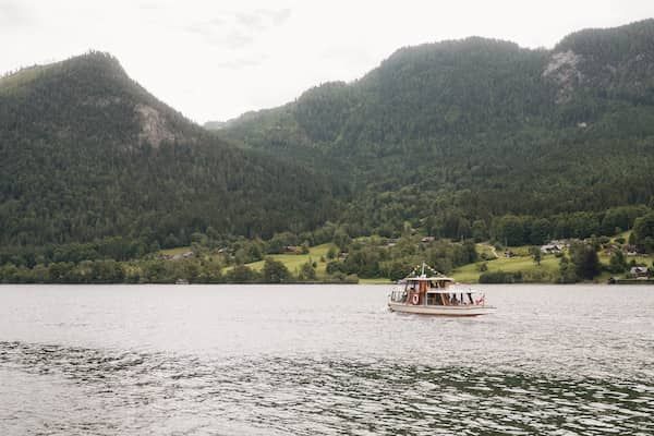 Ein Schiff mit der Hochzeitsgesellschaft darauf fährt über den Grundlsee.