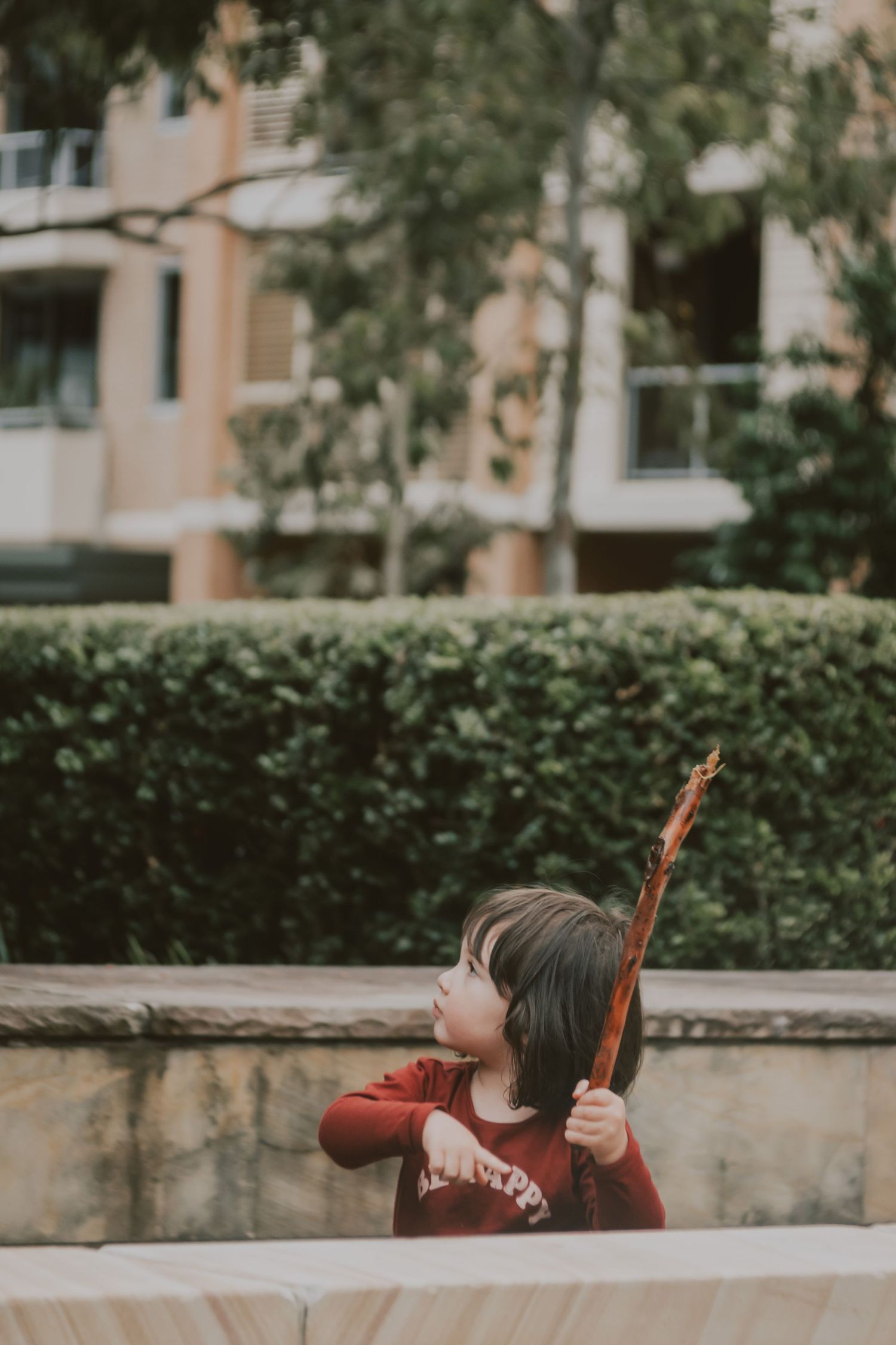 A young girl is playing with her stick. It was captured with a camera.