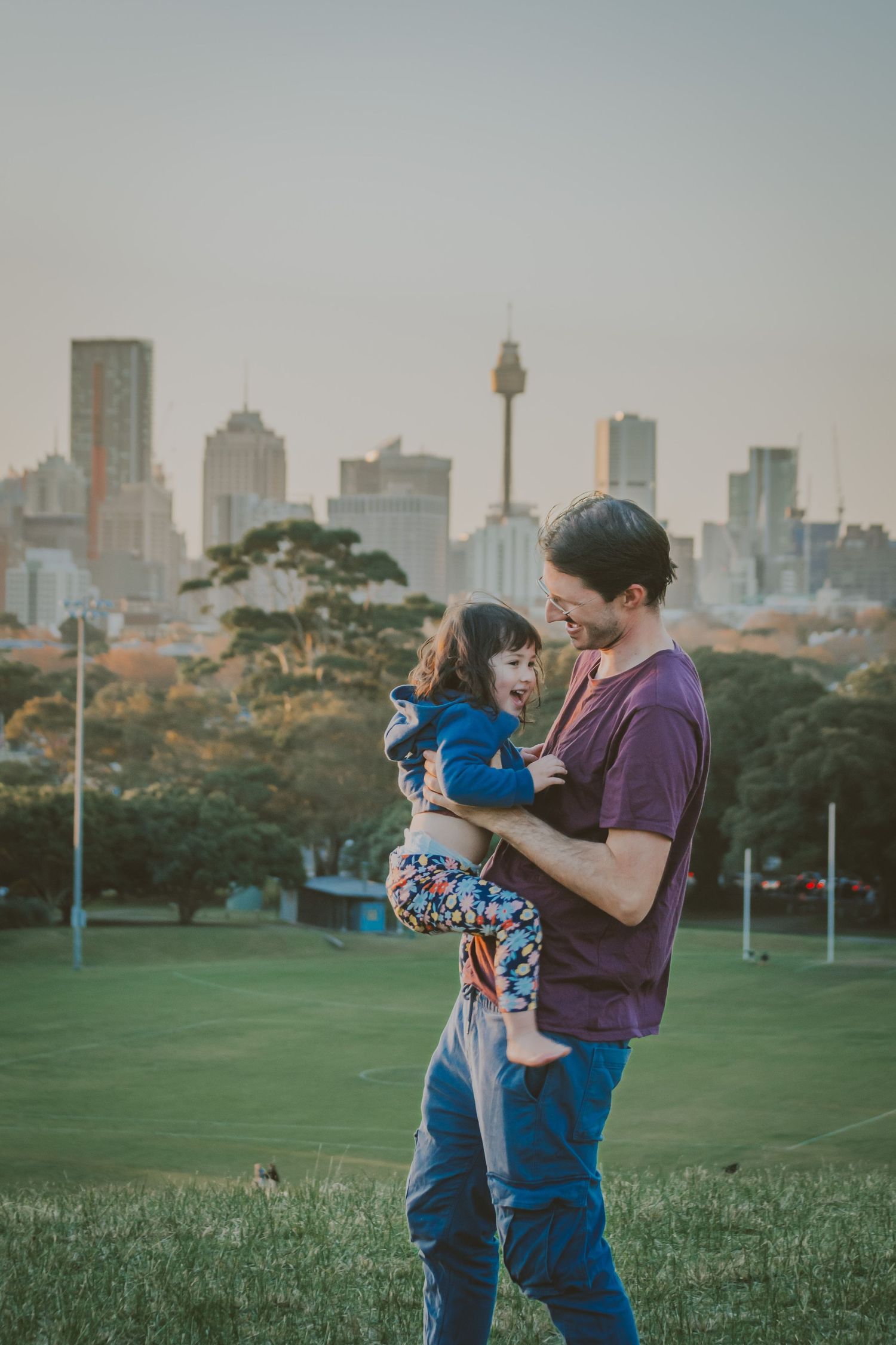 Dad and daughter are enjoying playing together while their photos are being captured.
