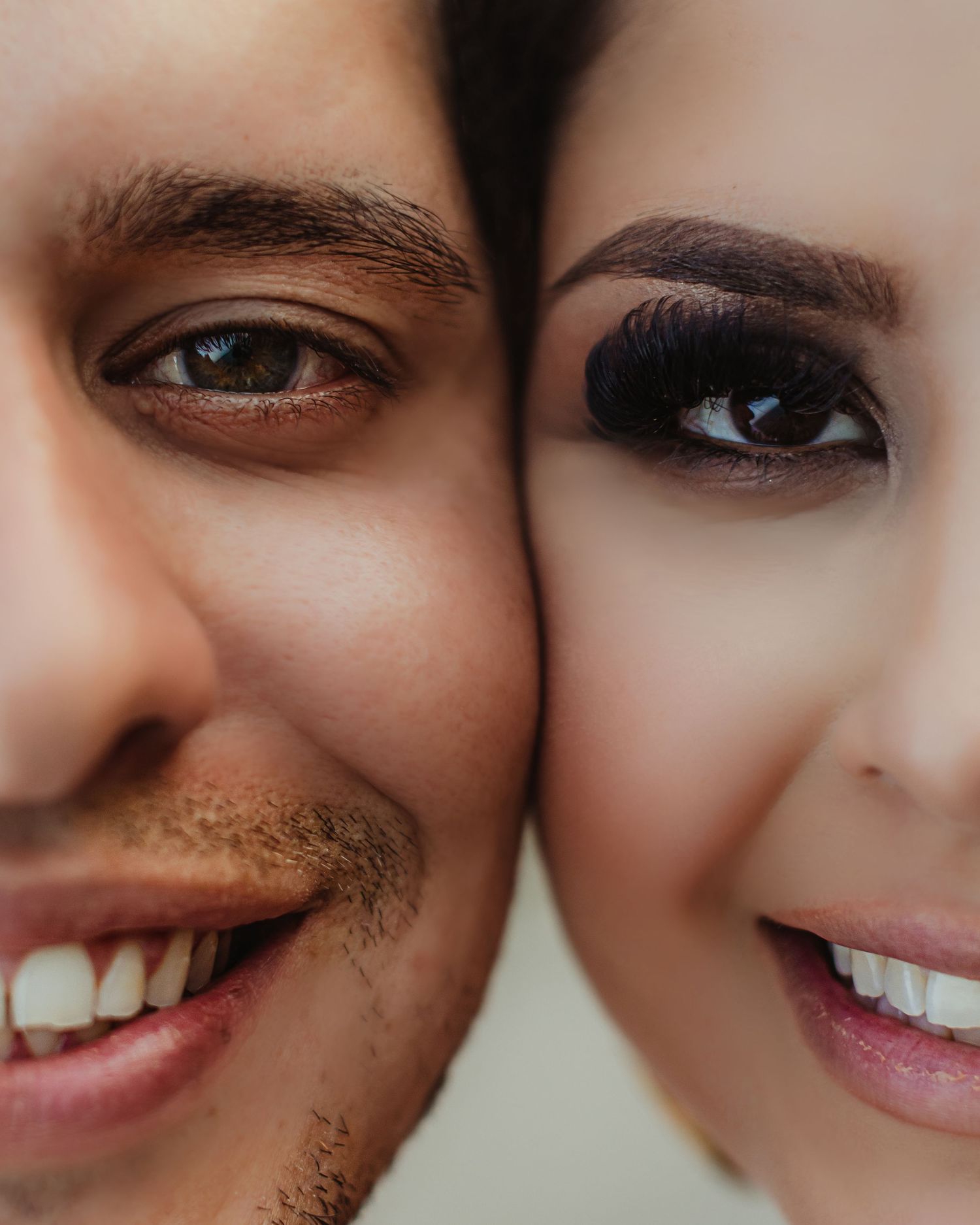Close-up portrait of a couple's faces side by side, showcasing their eyes and smiles.