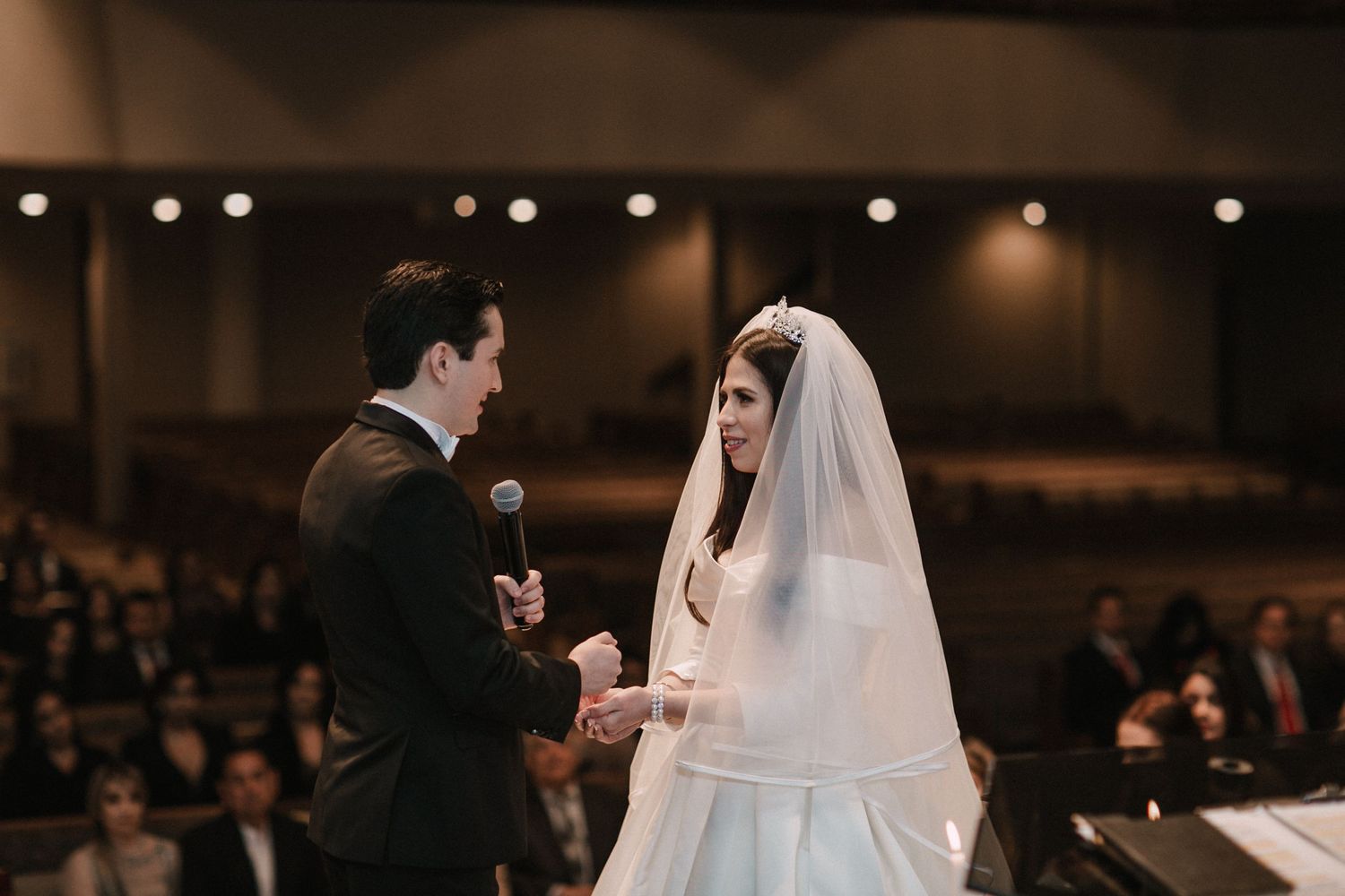 Bride and groom exchange vows at the altar during their wedding ceremony in a church.