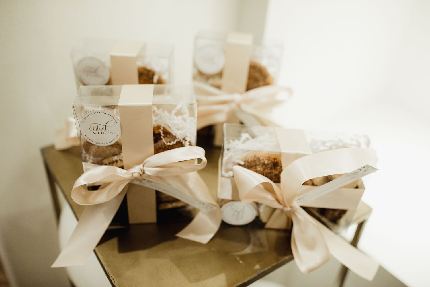 Small glass jars with ivory ribbon bows arranged on display, featuring homemade favors or gifts with rustic styling.