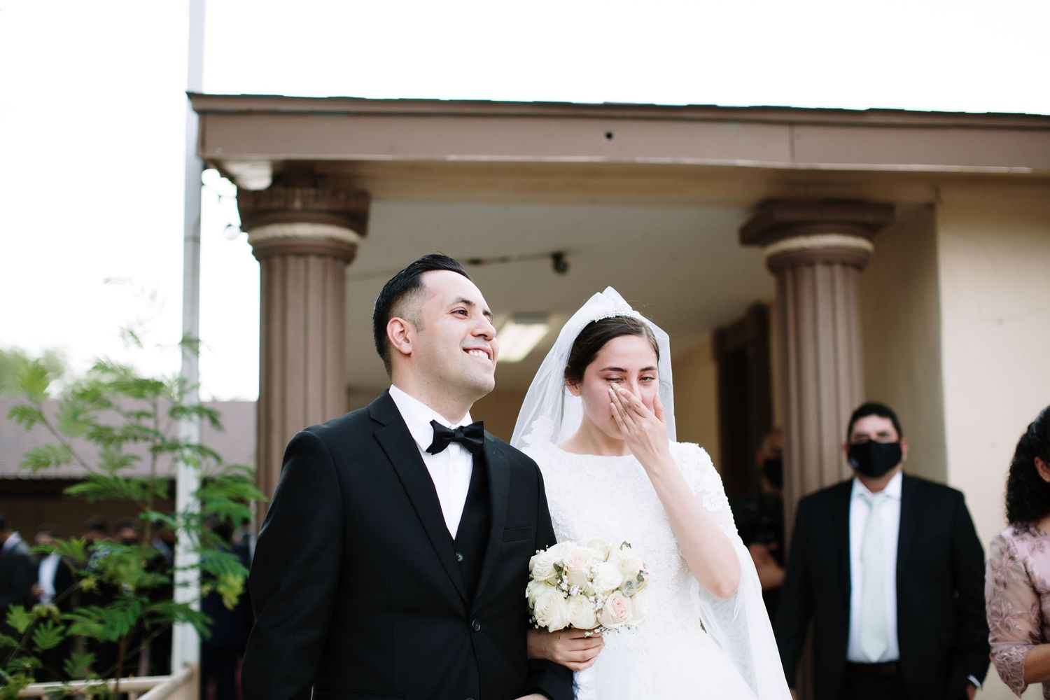 Bride and groom smiling as they exit the church after their wedding ceremony.