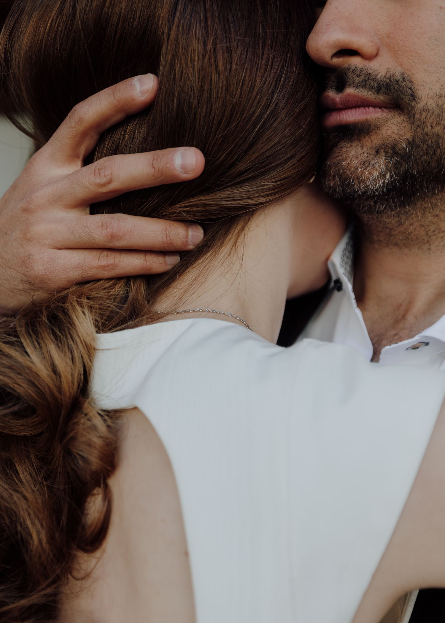 Intimate close-up of an embrace with focus on flowing hair and gentle touch.