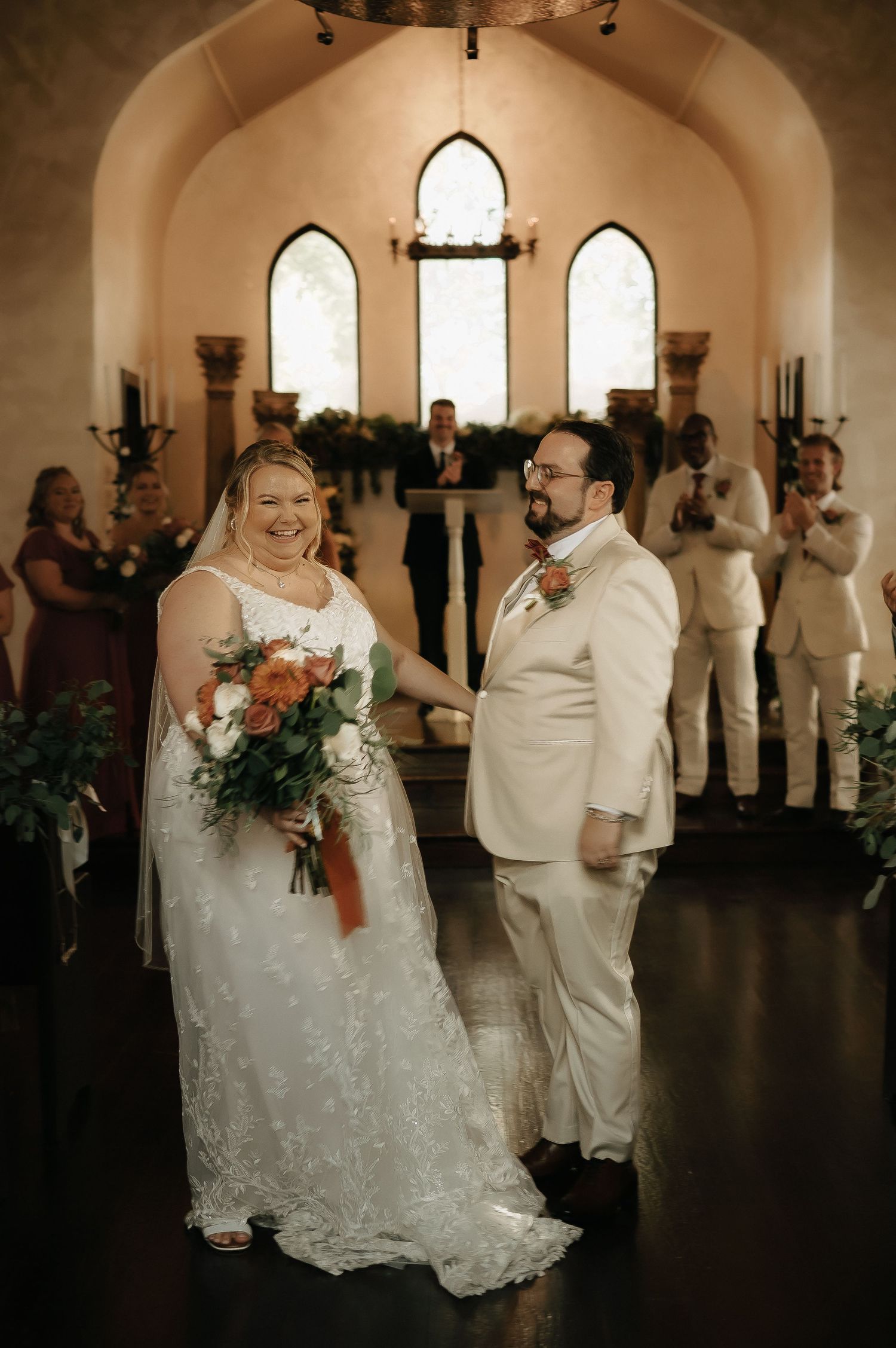 Chapel wedding ceremony with gothic windows and romantic lighting creating an intimate atmosphere.