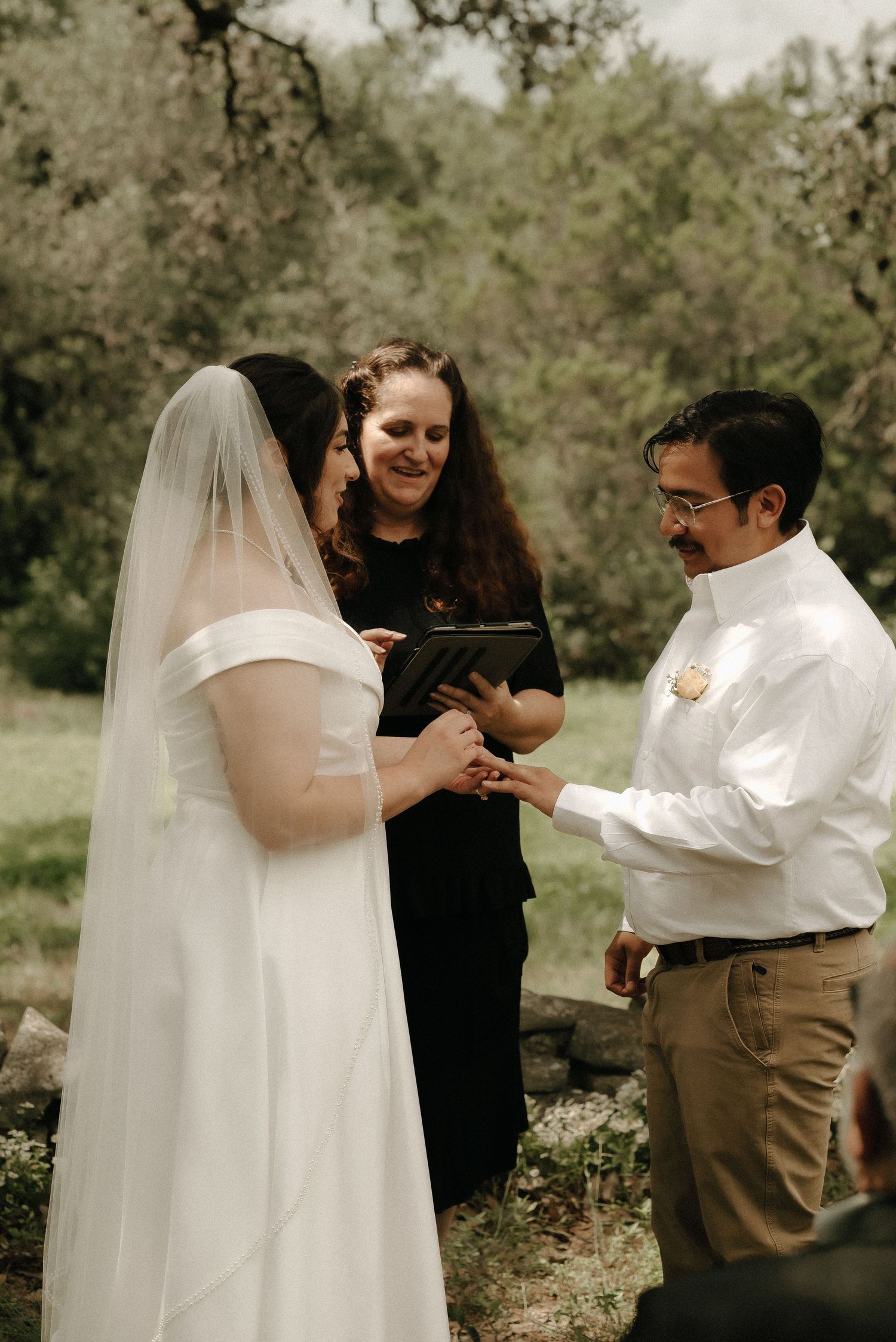 An intimate wedding ceremony unfolds in a peaceful woodland setting.
