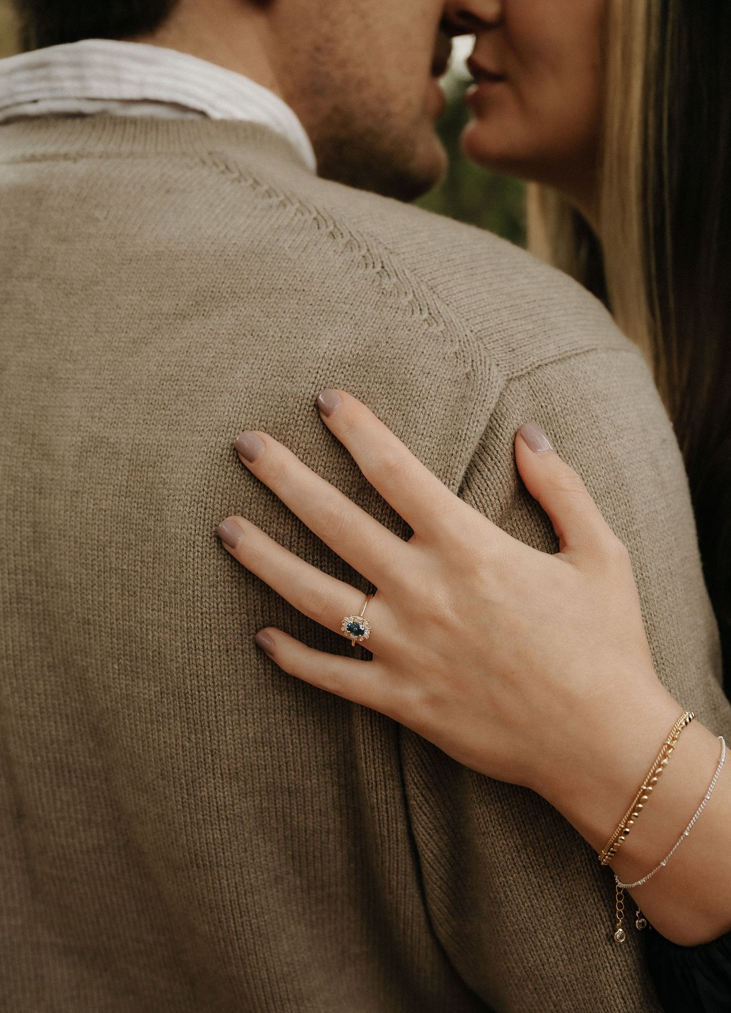 Close-up of hands showing engagement ring and delicate bracelet details.