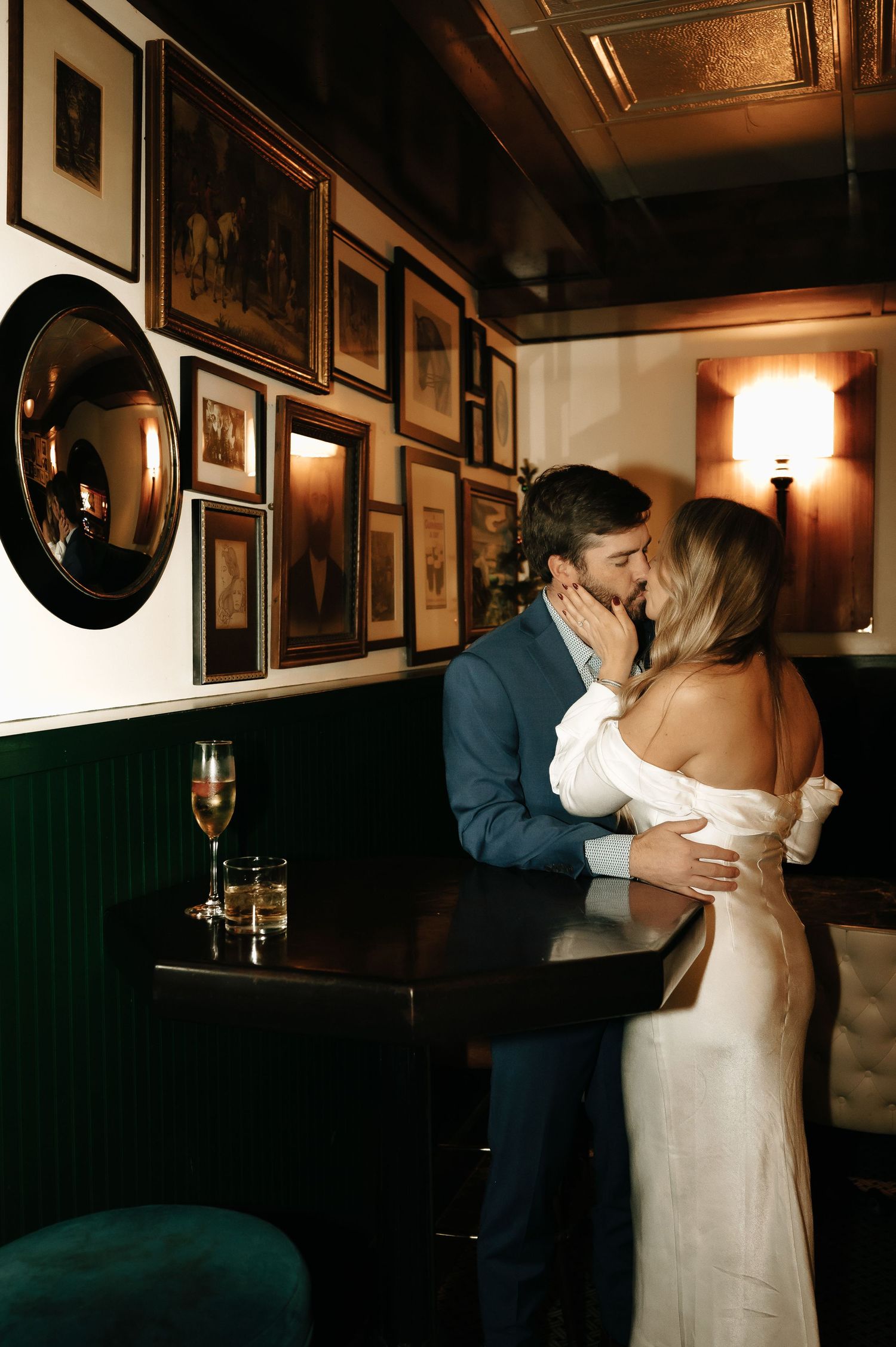 A romantic indoor wedding moment with a couple embracing in a dimly lit room with vintage decor.