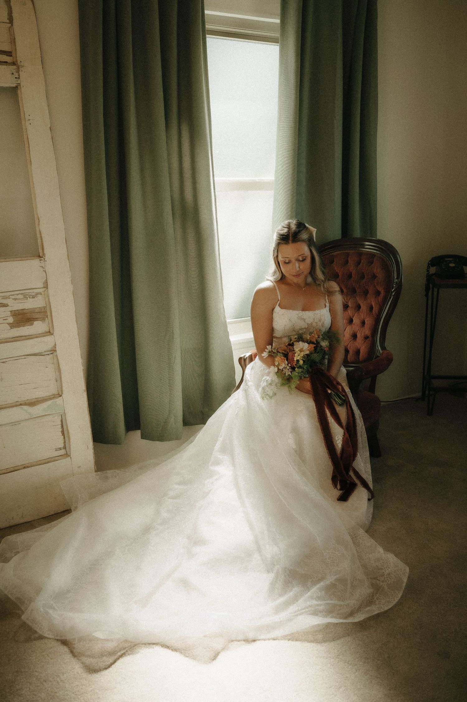 Ethereal bridal portraits in soft window light with flowing white gown.