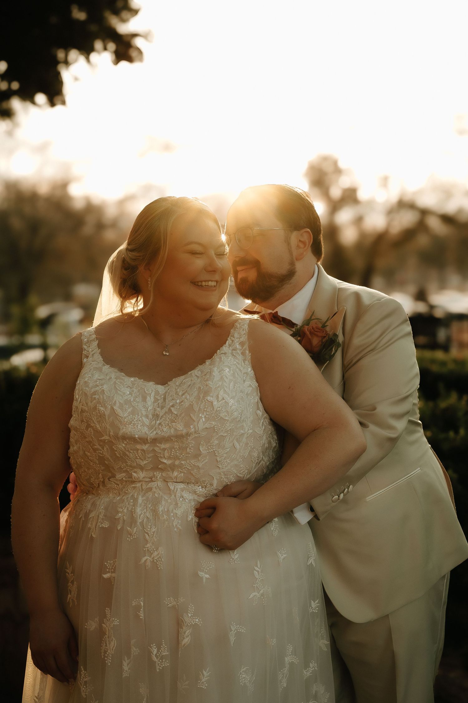 Joyful wedding couple shares an intimate moment during golden hour photography session.