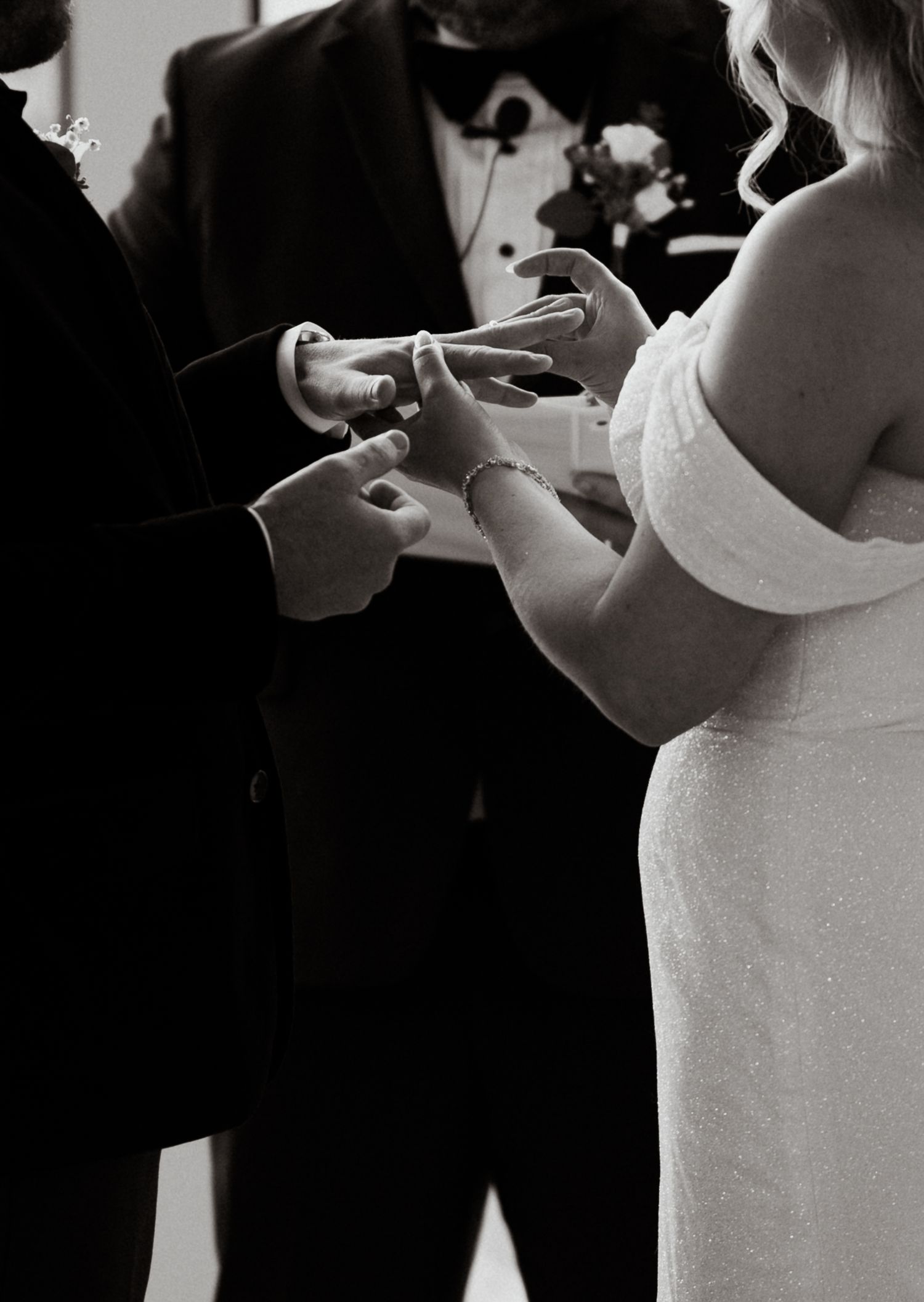 Black and white photo of a couple's first look wedding moment in dramatic lighting.