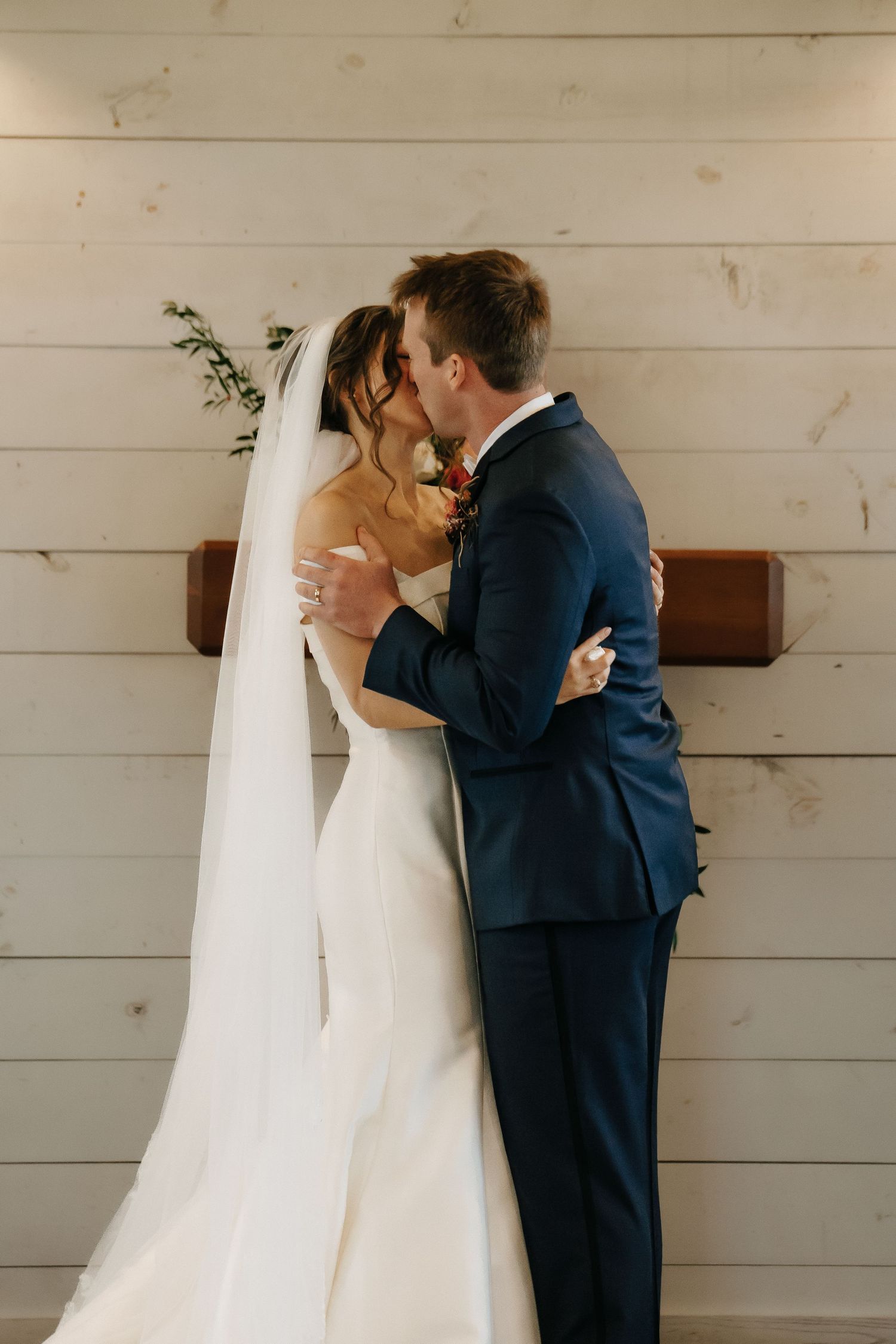 Romantic wedding sequence showing couple sharing intimate moment against white wooden wall.