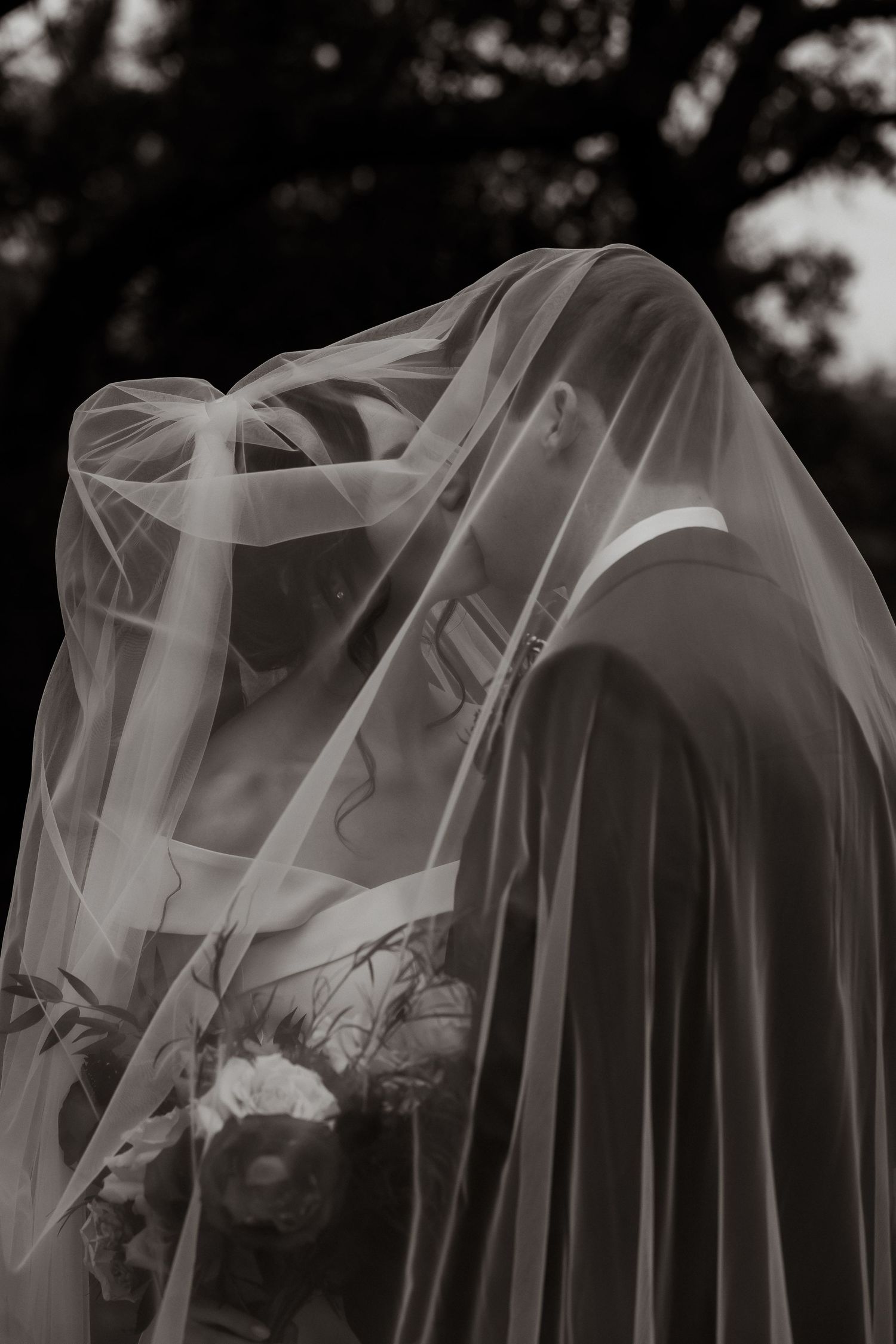 An artistic close-up of wedding veils creating ethereal layers and textures in black and white.