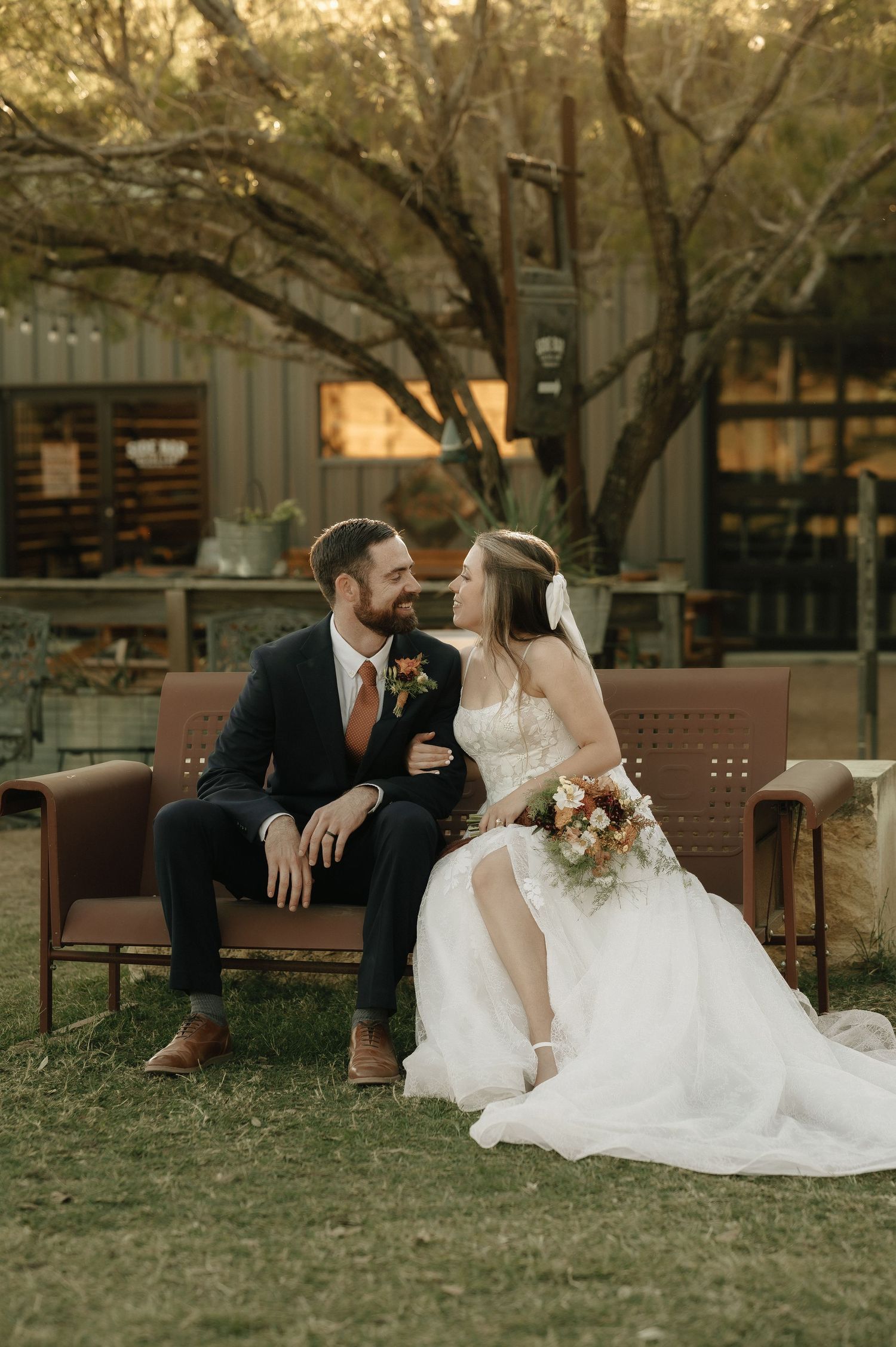 Romantic sunset wedding photos on rustic outdoor bench.