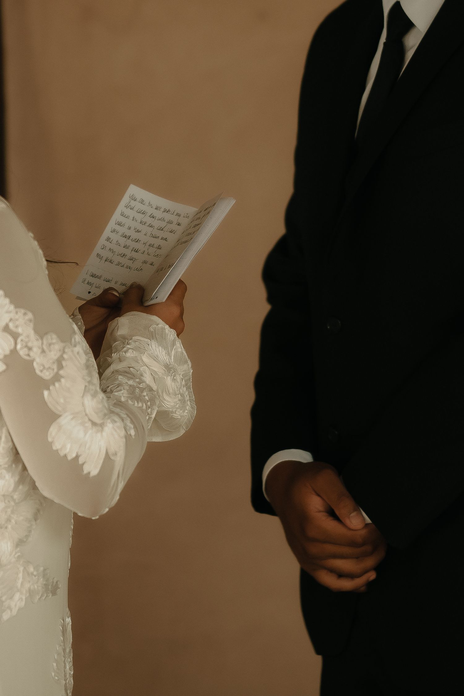 Close-up sequence of hands holding wedding vow books during ceremony.