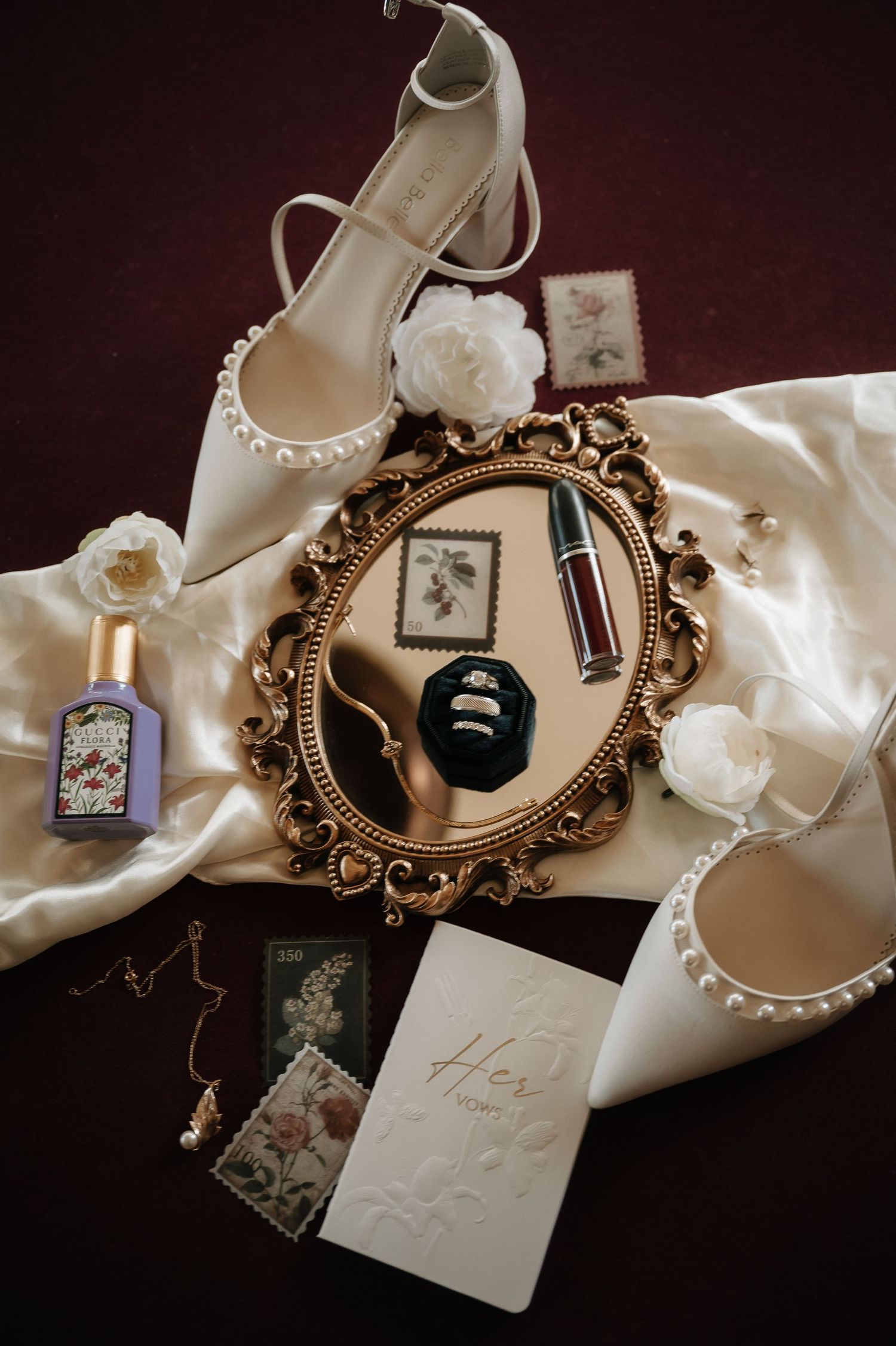 Vintage-style wedding details including ornate mirrors, pearls, and delicate paper elements on dark background.