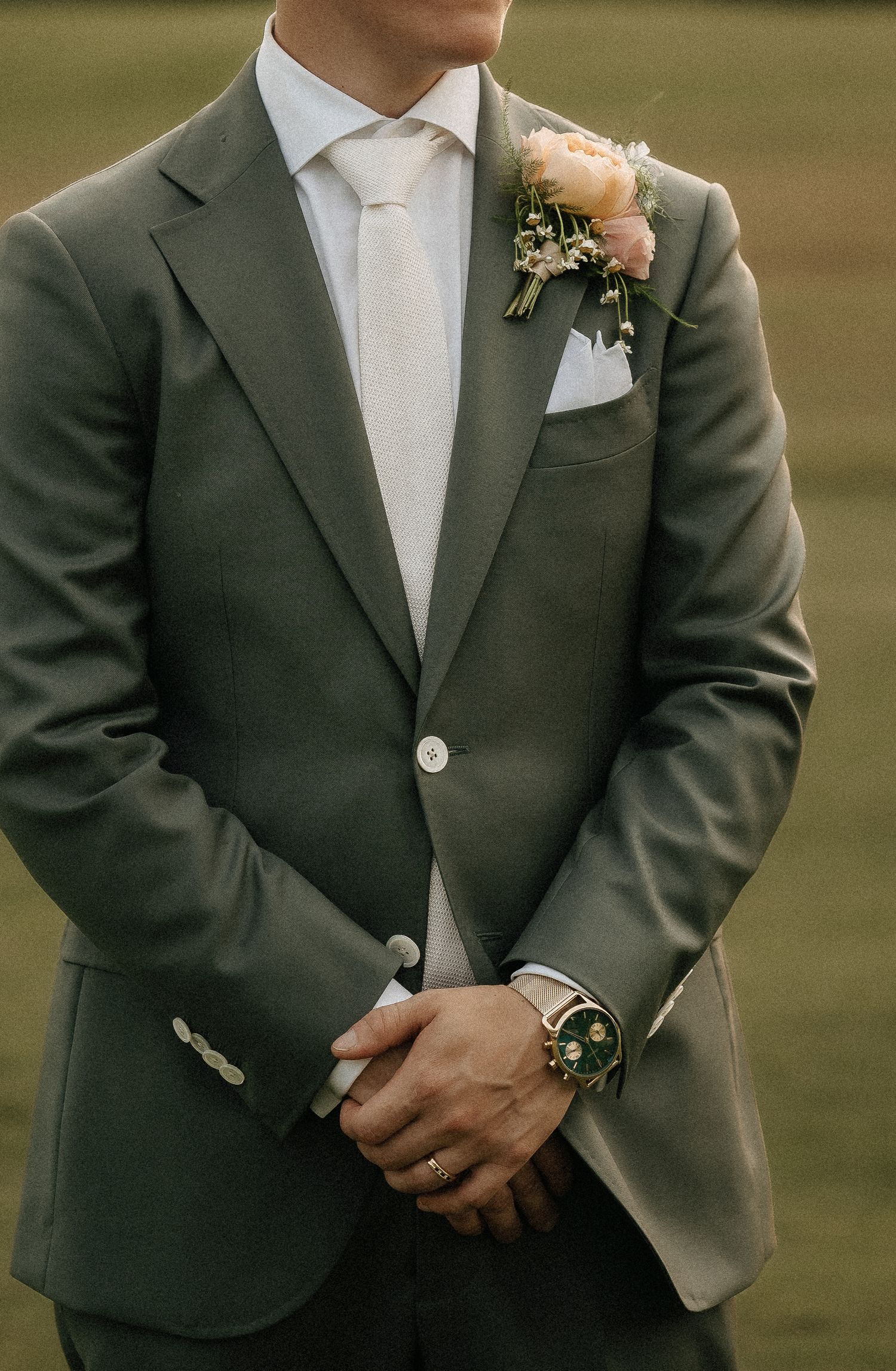Formal grey suit with white boutonniere and tie for wedding attire.