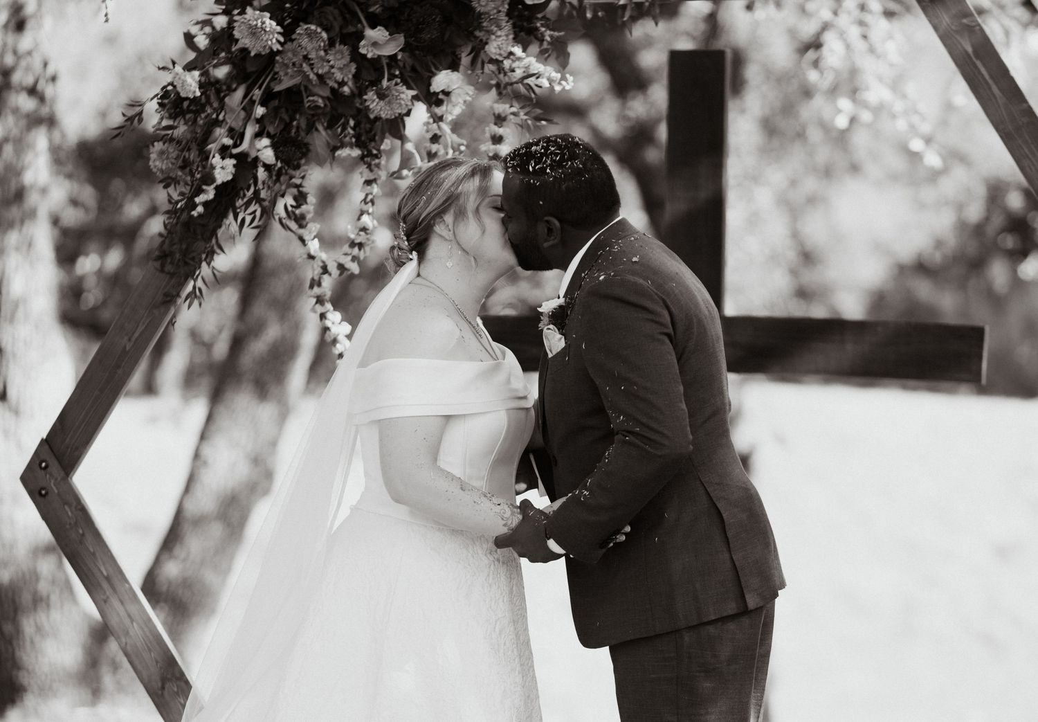 Romantic winter wedding portraits in black and white with snowy backdrop.