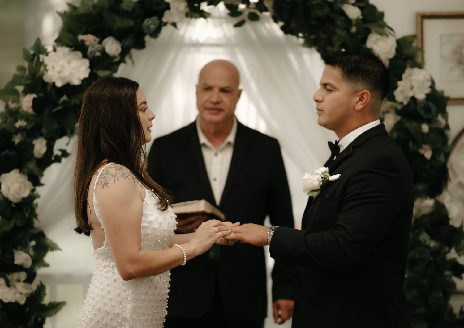 Elegant indoor wedding reception with floral decorations and formal attire.