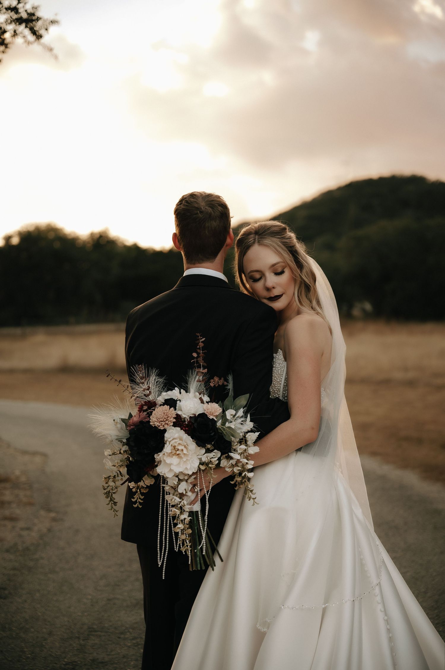 Romantic sunset portraits of couple in wedding attire with dramatic lighting.