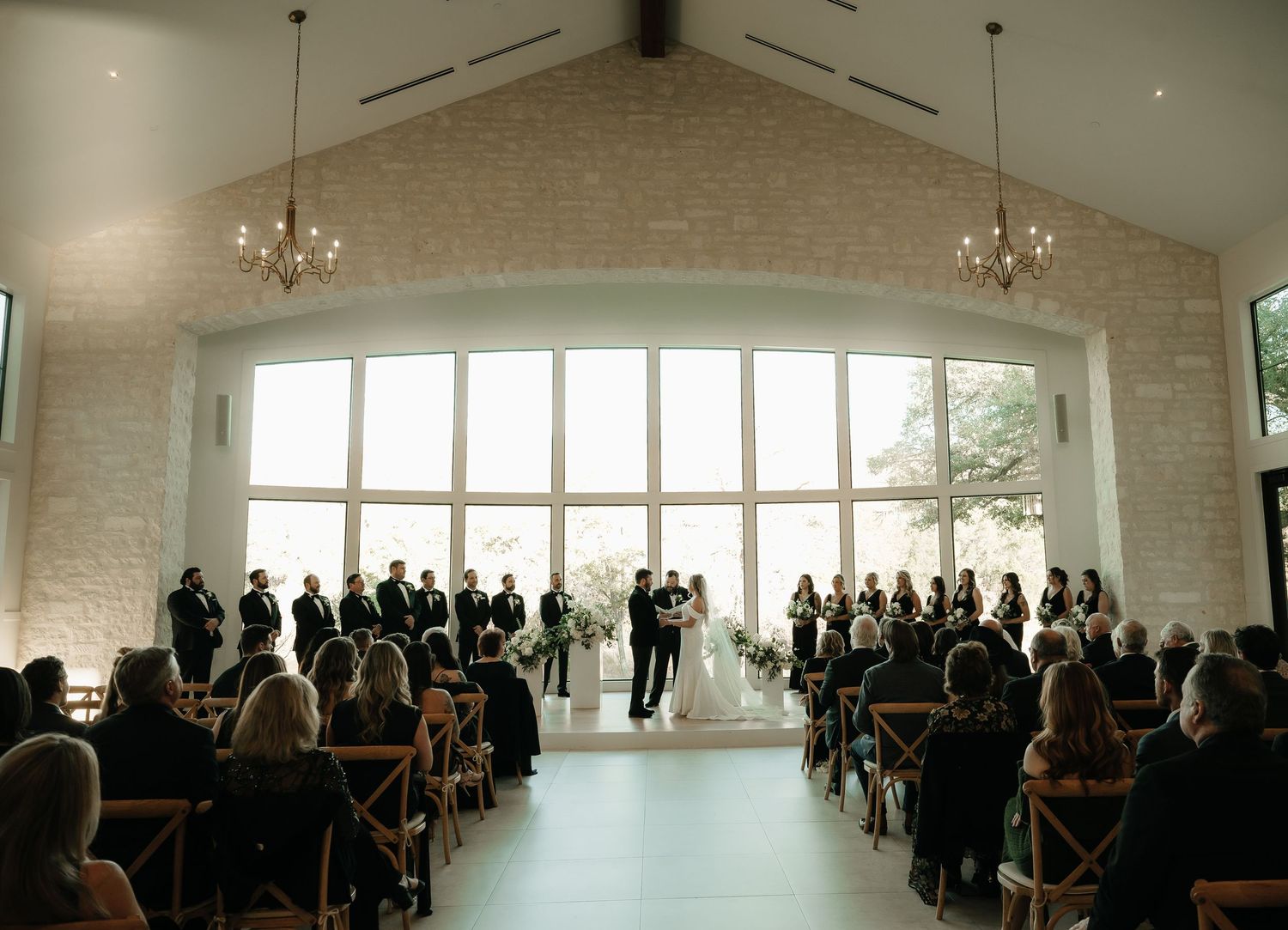 Panoramic view of an elegant white wedding venue filled with guests.