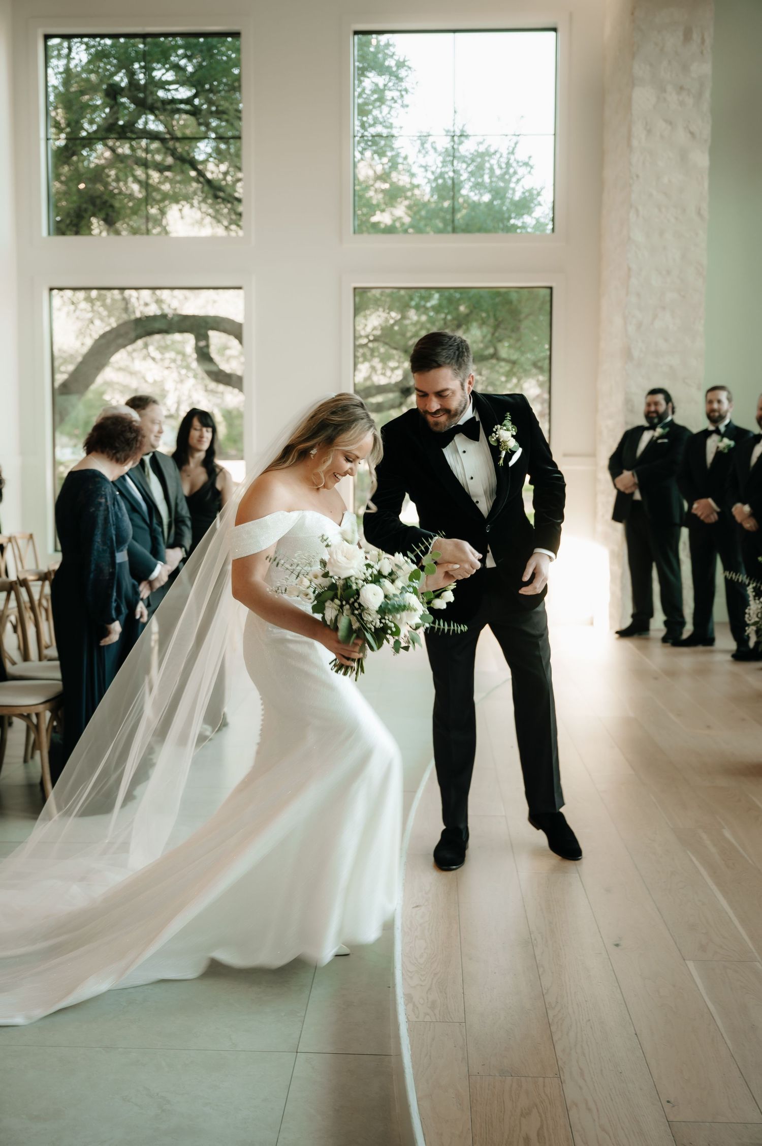Wedding celebration in a modern white venue with elegant hardwood floors.