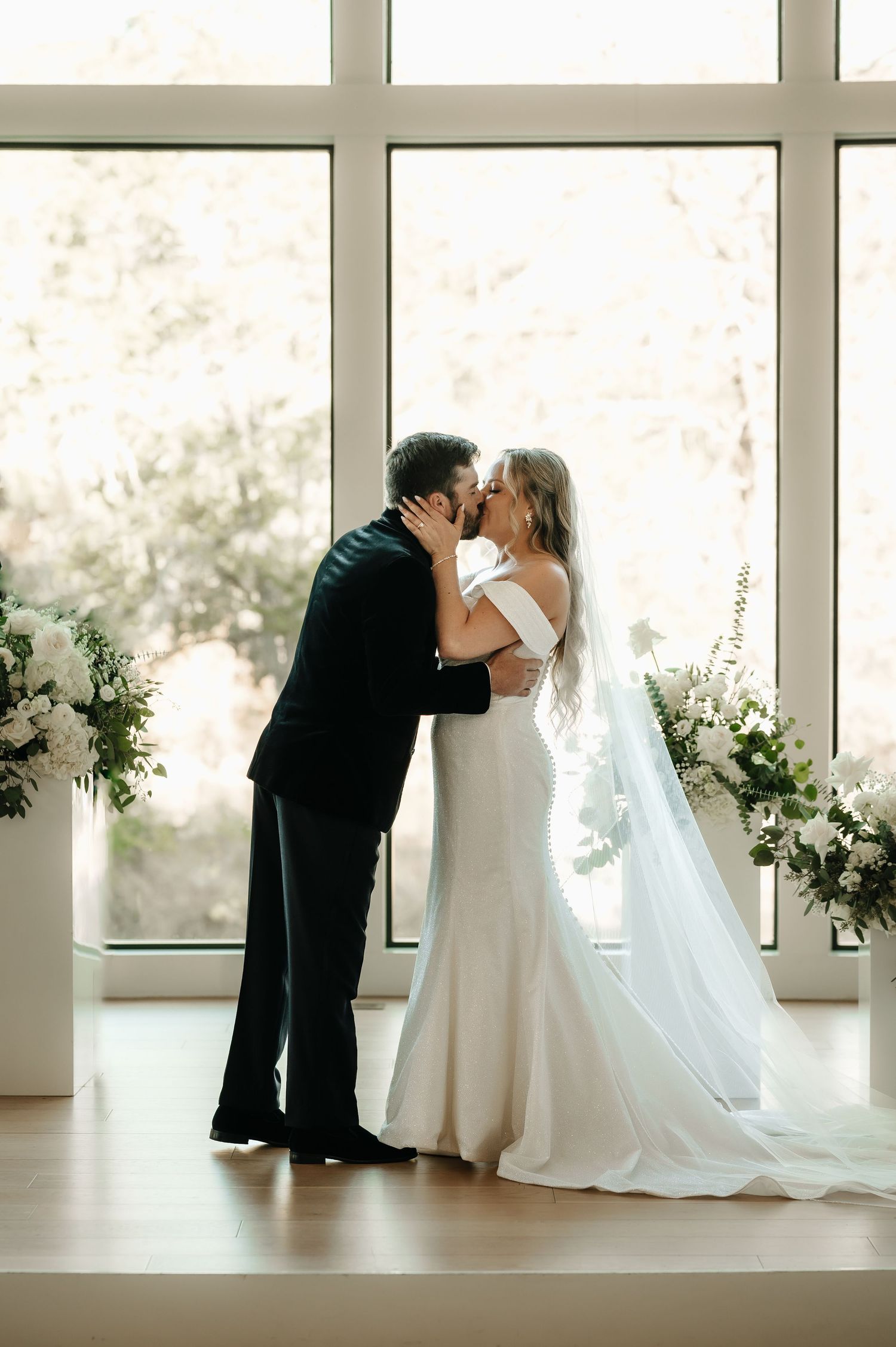 Intimate wedding portraits captured in bright indoor setting with window light.