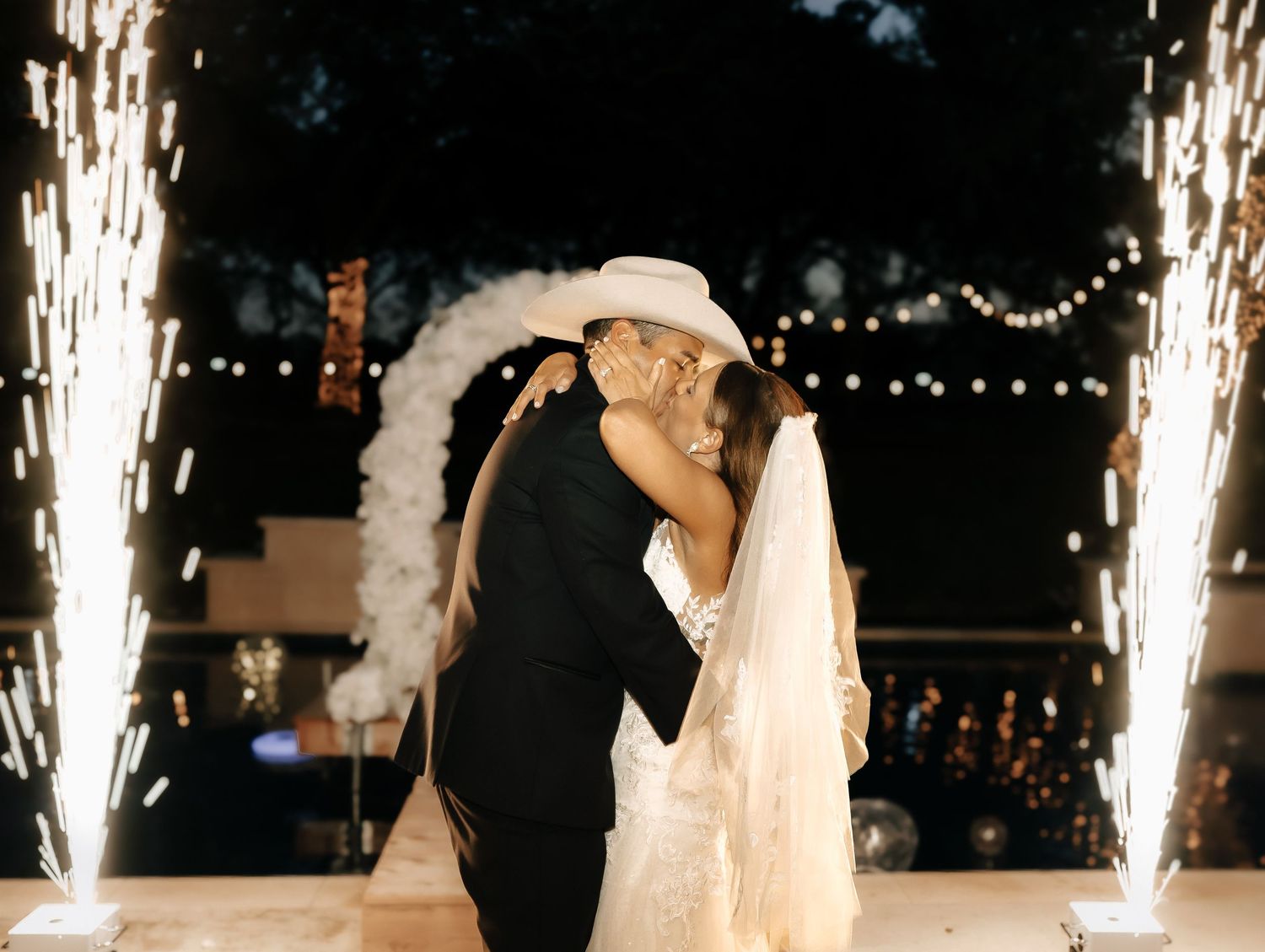 Wedding reception celebration with sparklers and dancing silhouettes.