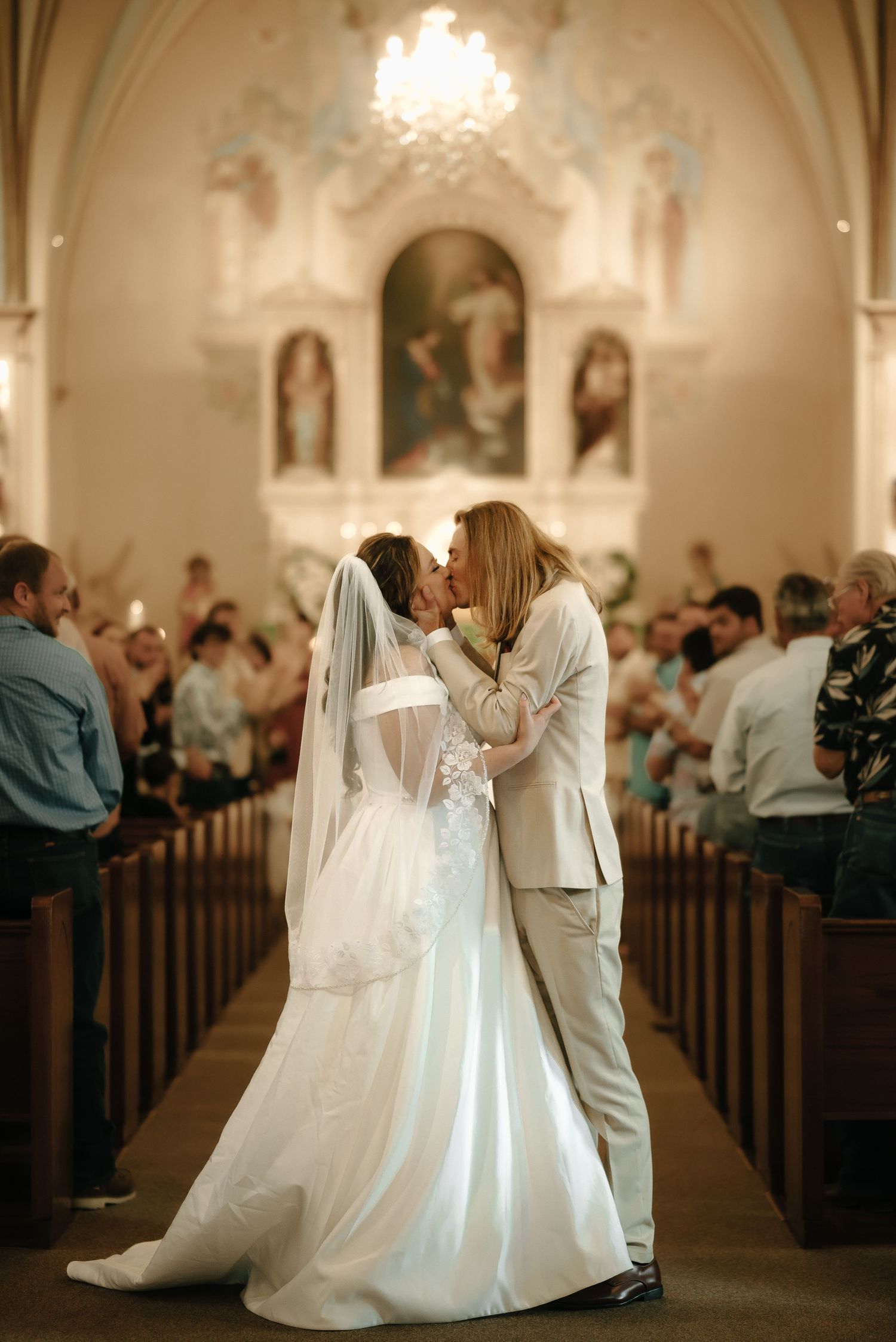 Wedding ceremony in a traditional church with elegant lighting and ornate architectural details.