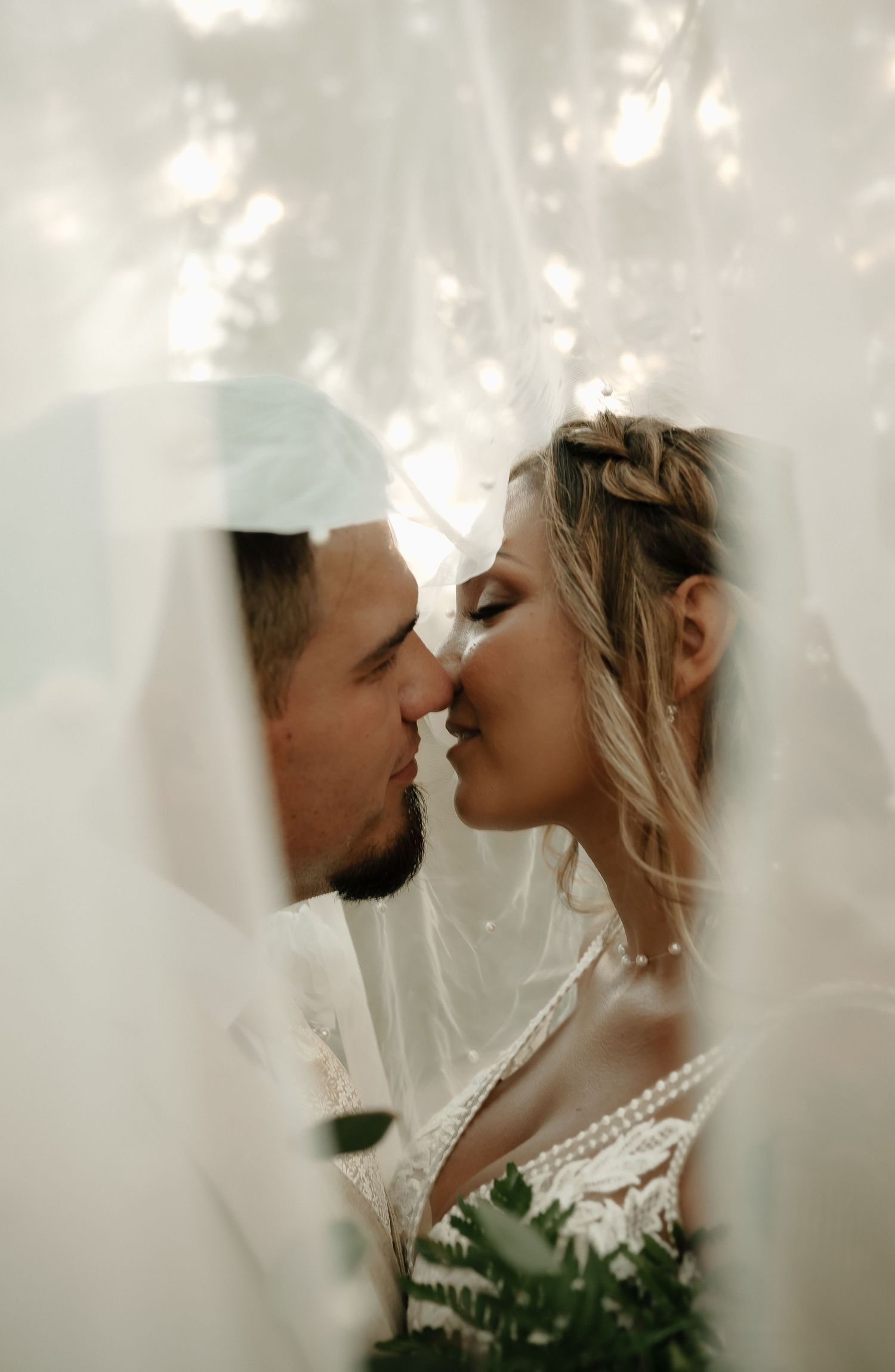 Intimate moment captured through sheer fabric with soft lighting.