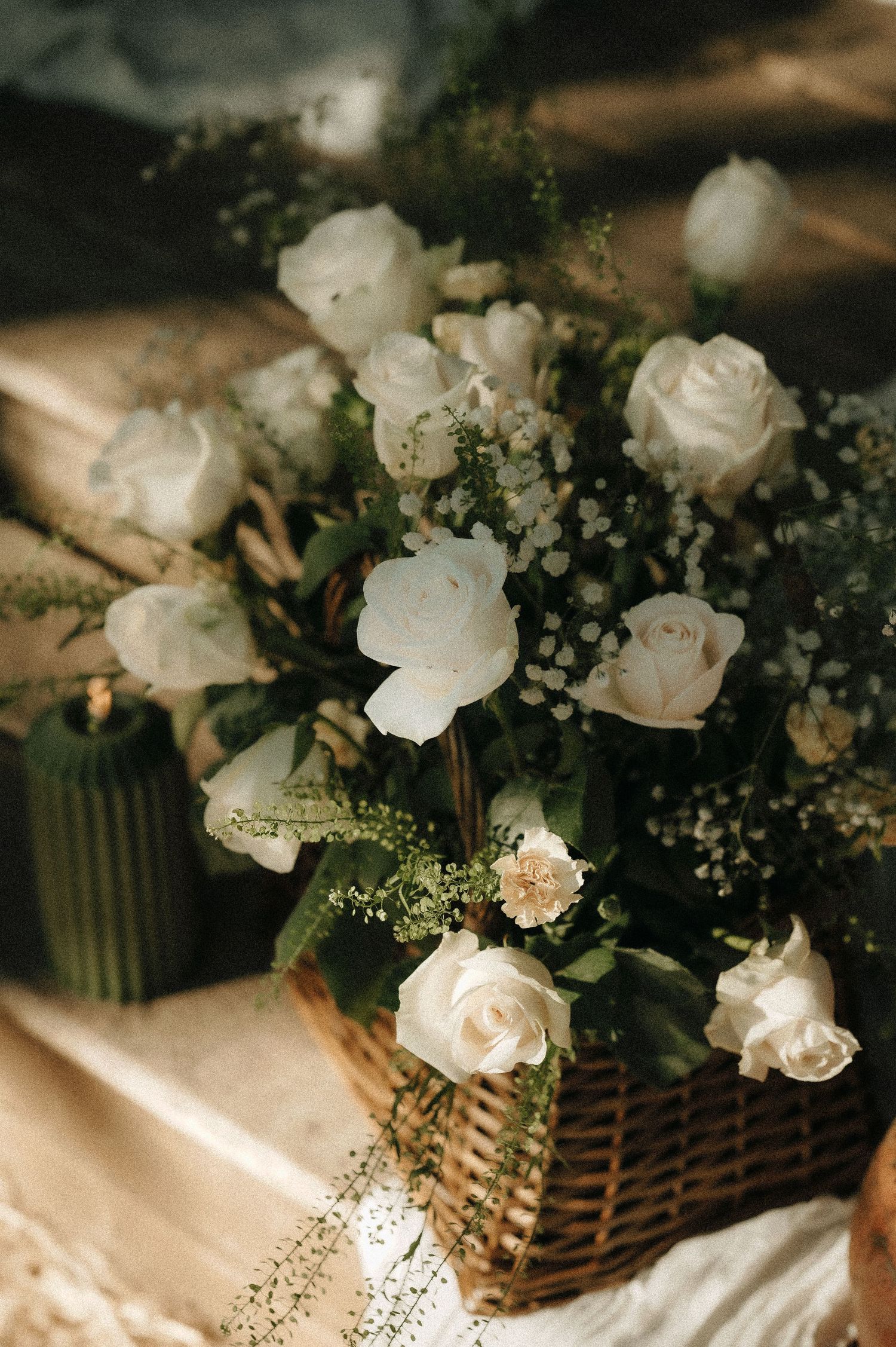Close-up of delicate white roses and baby's breath wedding flower arrangement.