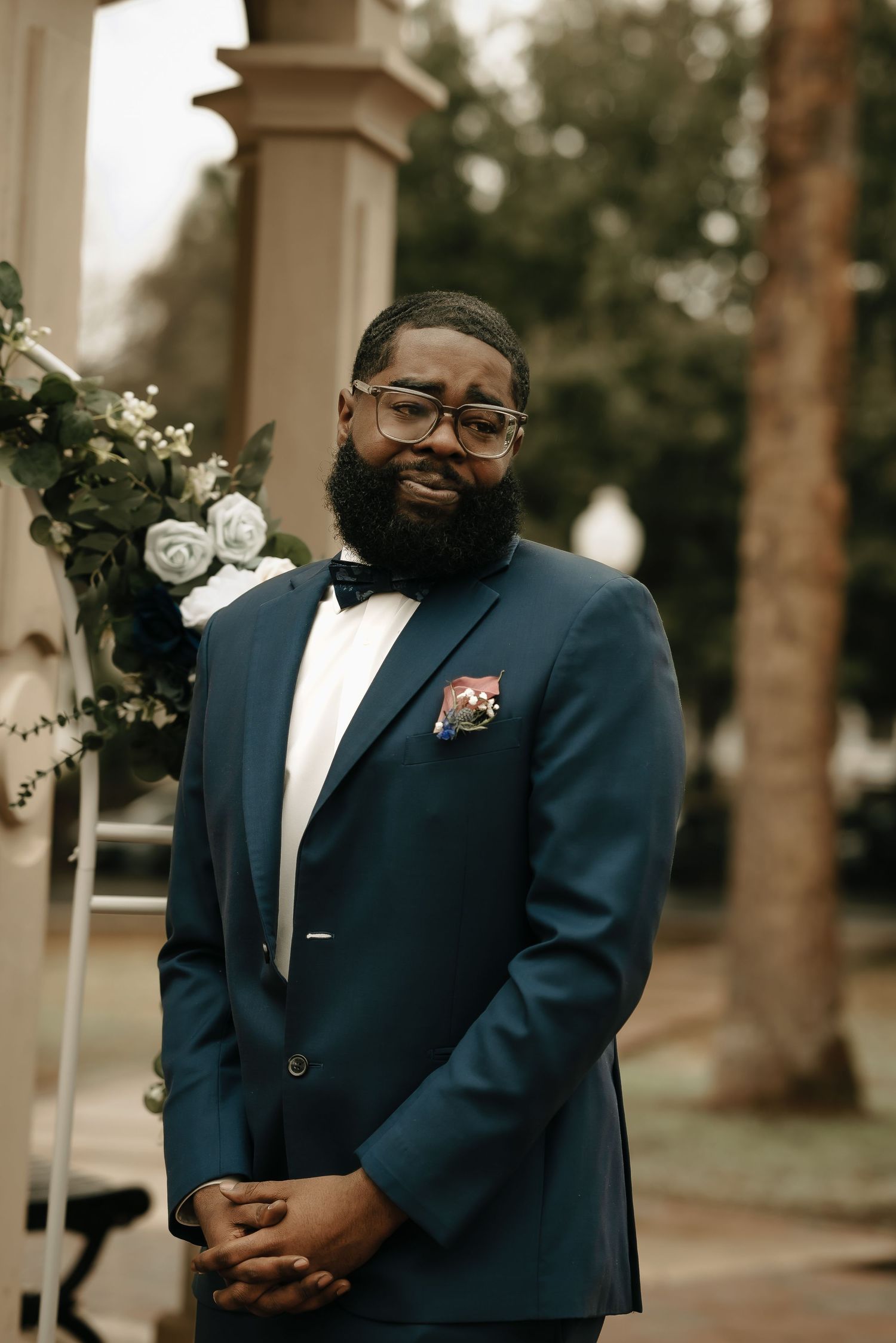 Groom in navy suit waiting thoughtfully before the wedding ceremony.