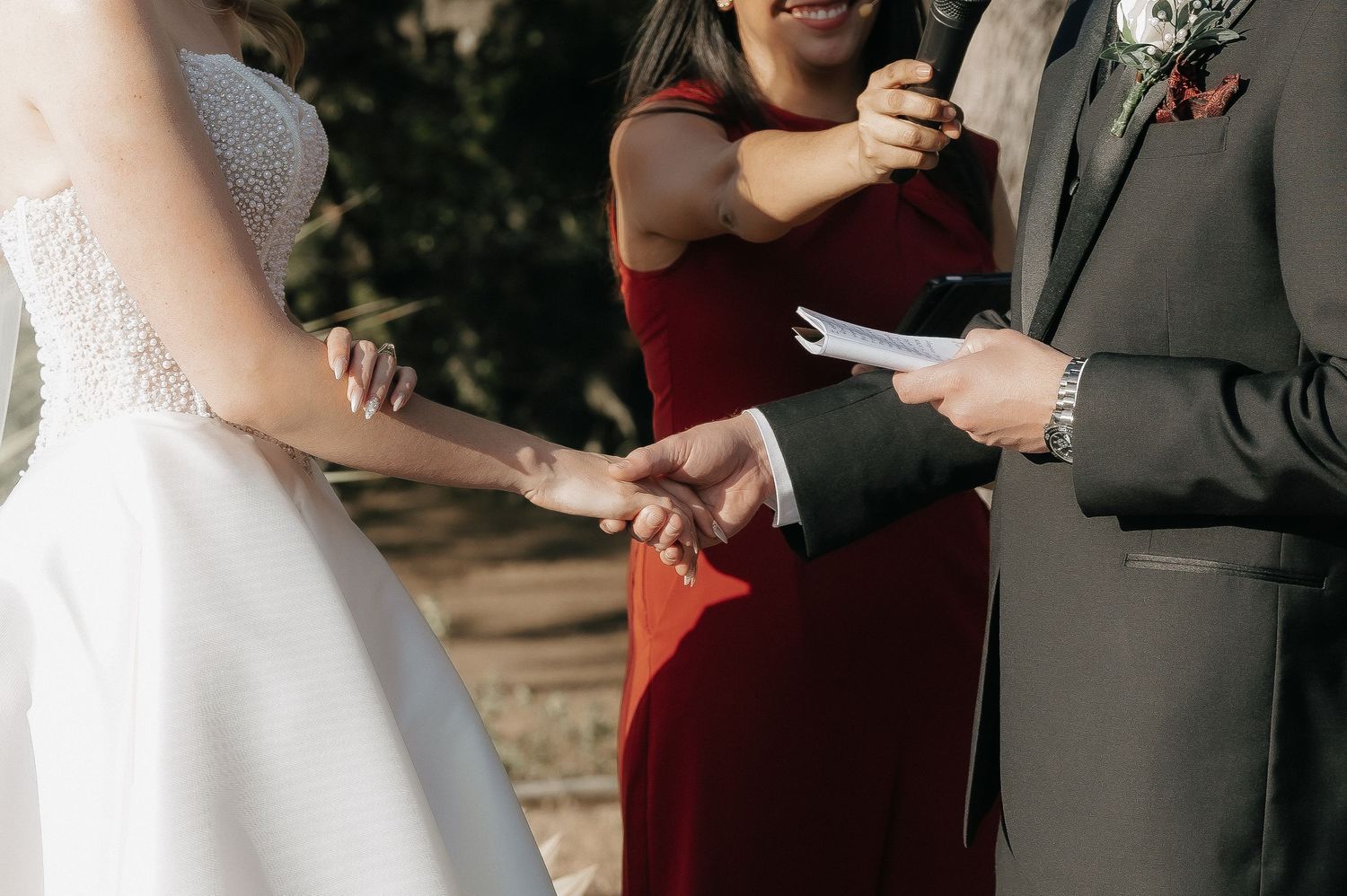Close-up shots of wedding ceremony ring exchange under wooden arch.