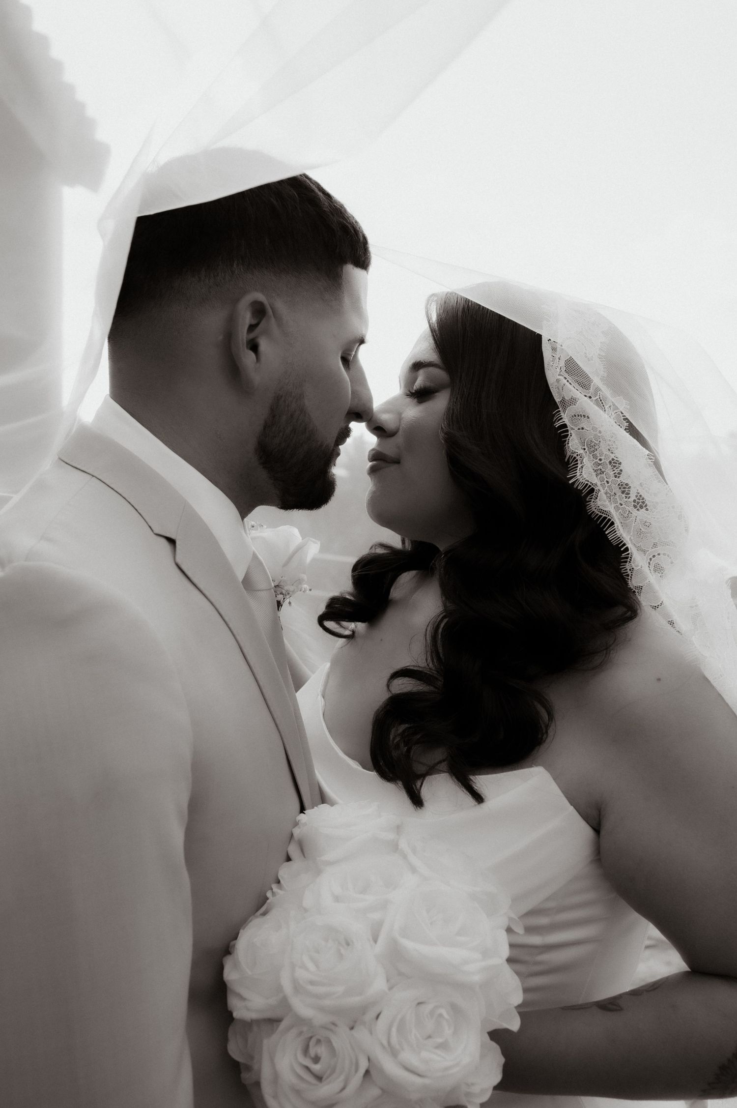 Romantic black and white portrait series of newlyweds sharing intimate moments.