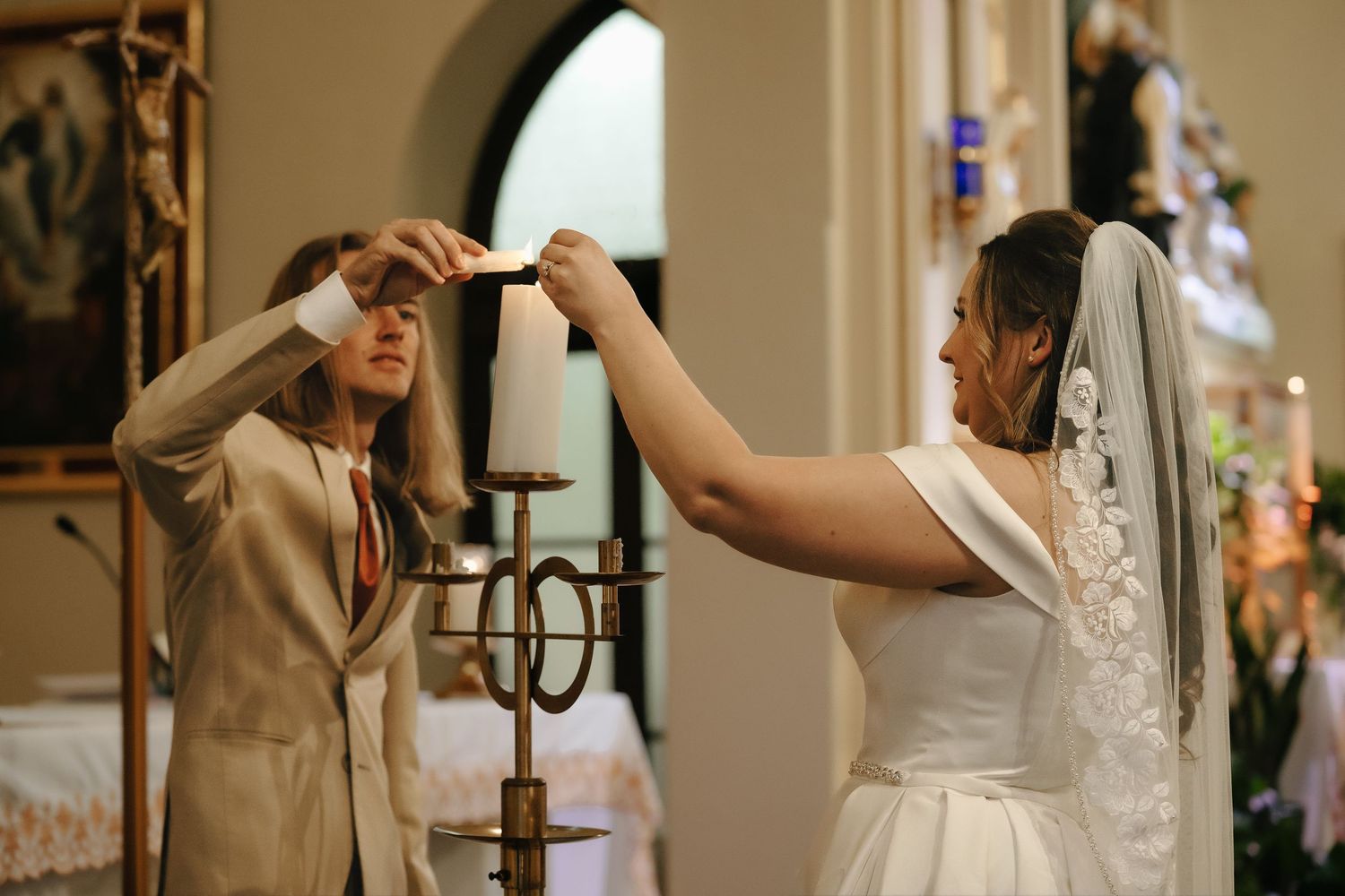 Wedding ceremony moments captured inside a church with arched doorways and warm lighting.