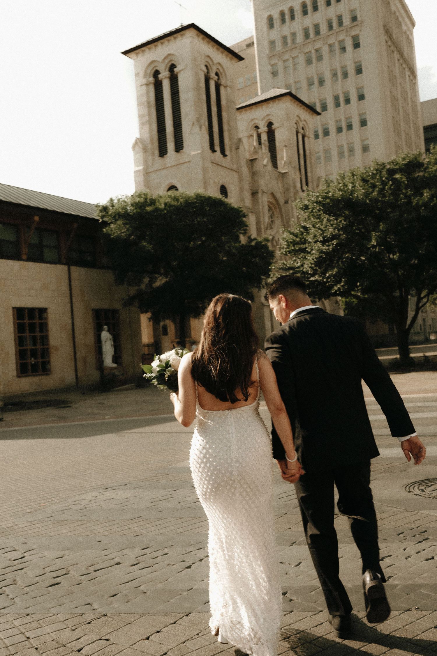 Artistic wedding photo sequence of a couple walking near a historic stone building.
