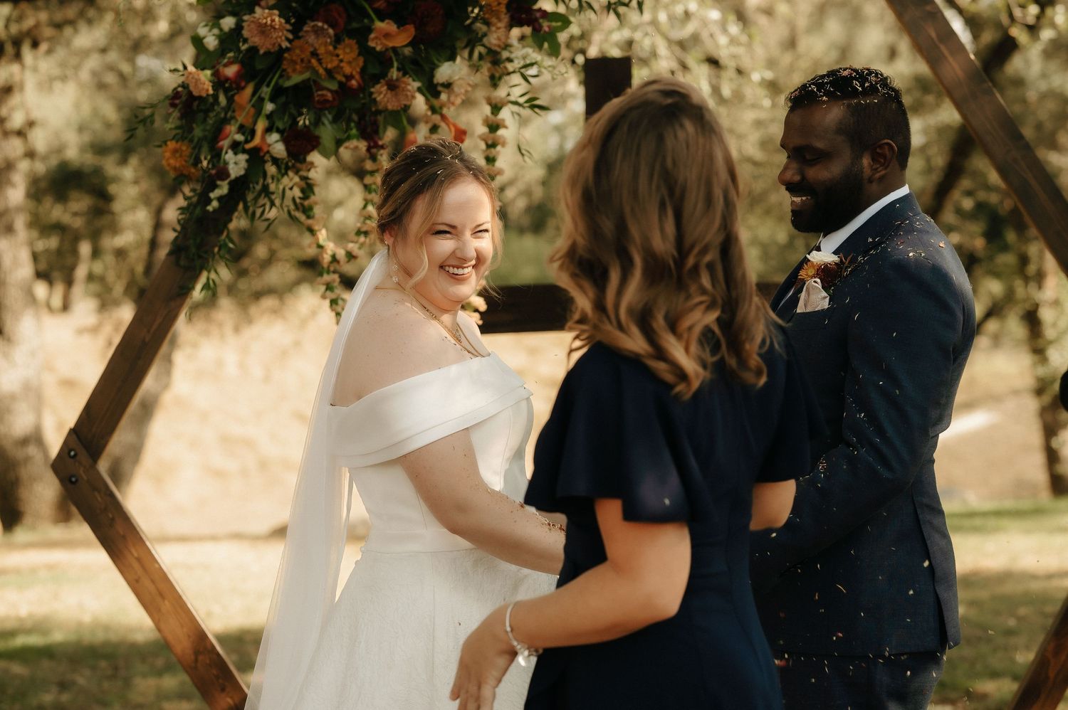 Wedding party members celebrate with sparklers during an outdoor ceremony.