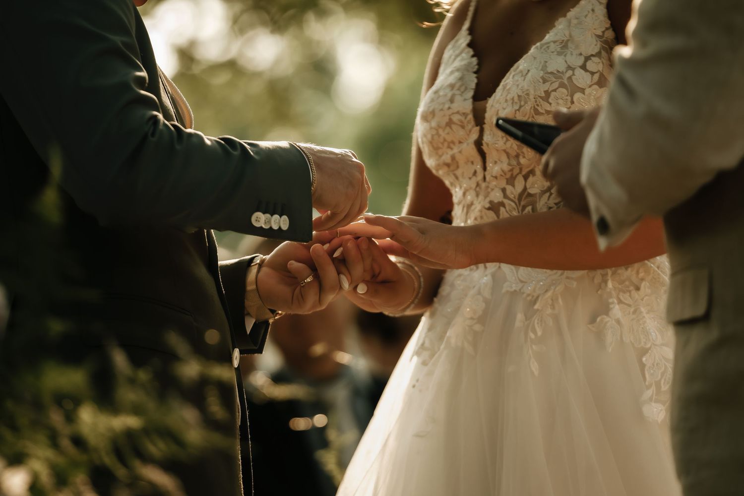 Close-up shots of wedding ceremony details with sunlight filtering through trees.