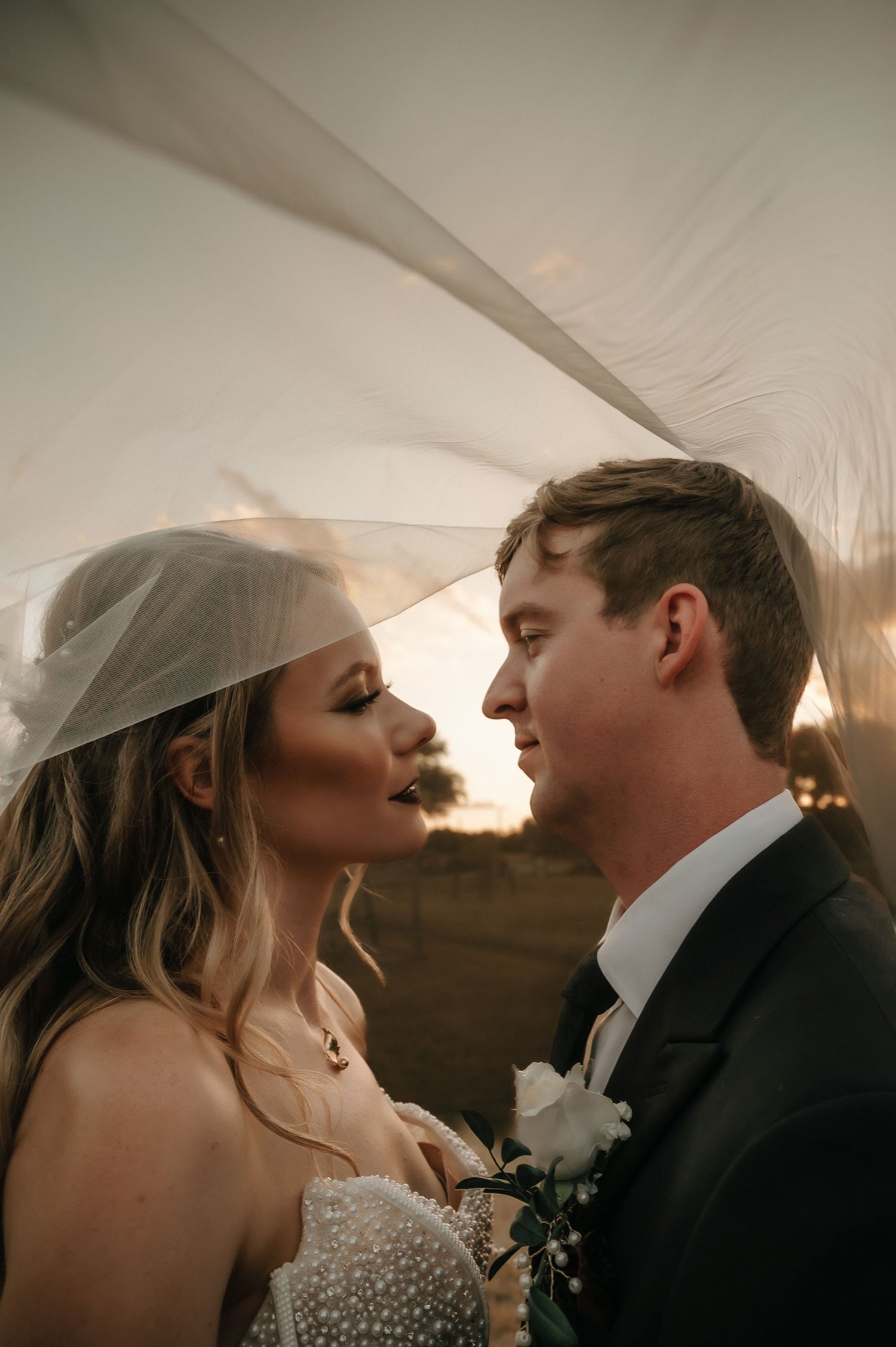 Intimate wedding couple moment captured under reception tent lighting.