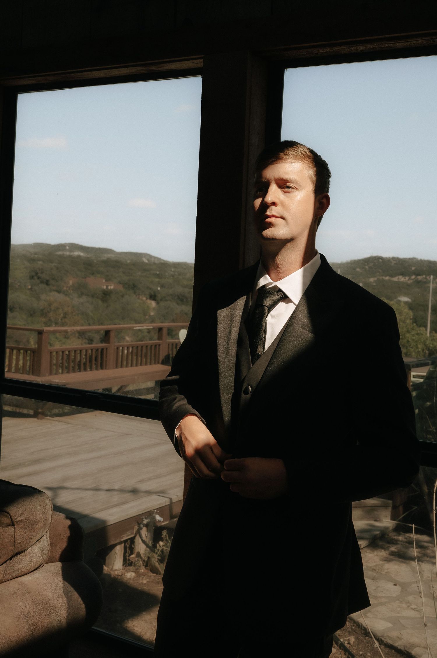 Silhouette against large windows overlooking a scenic mountain landscape.