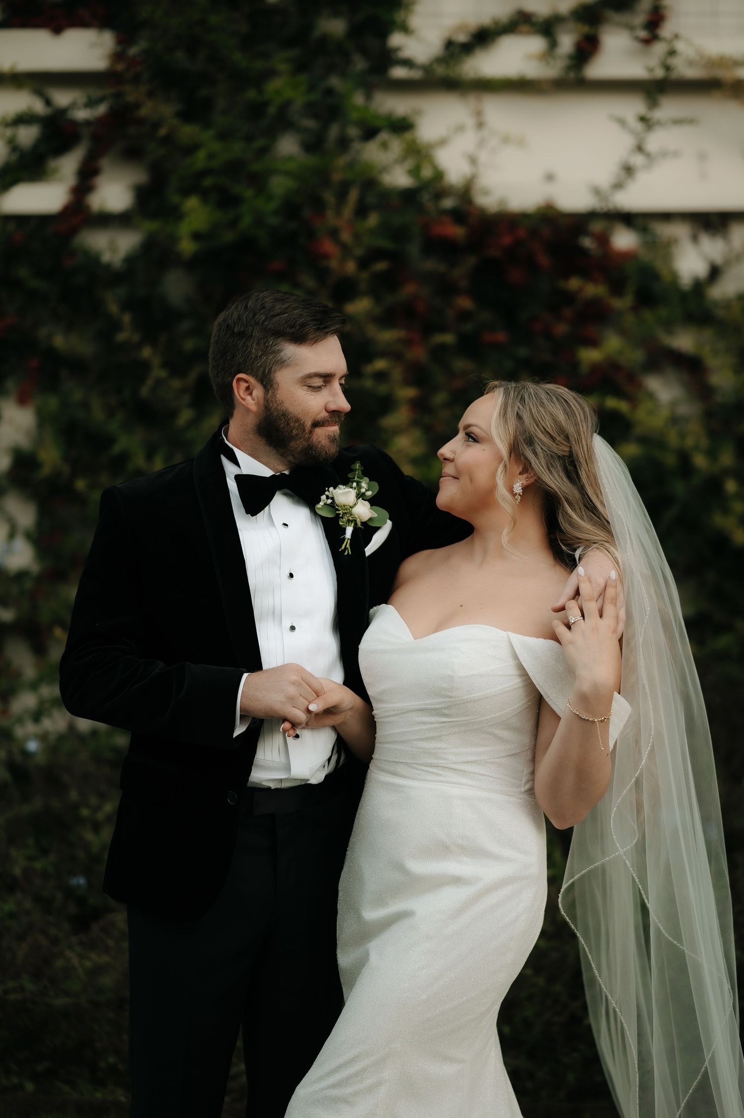 Elegant wedding portraits showing tender moments between bride and groom against garden backdrop.