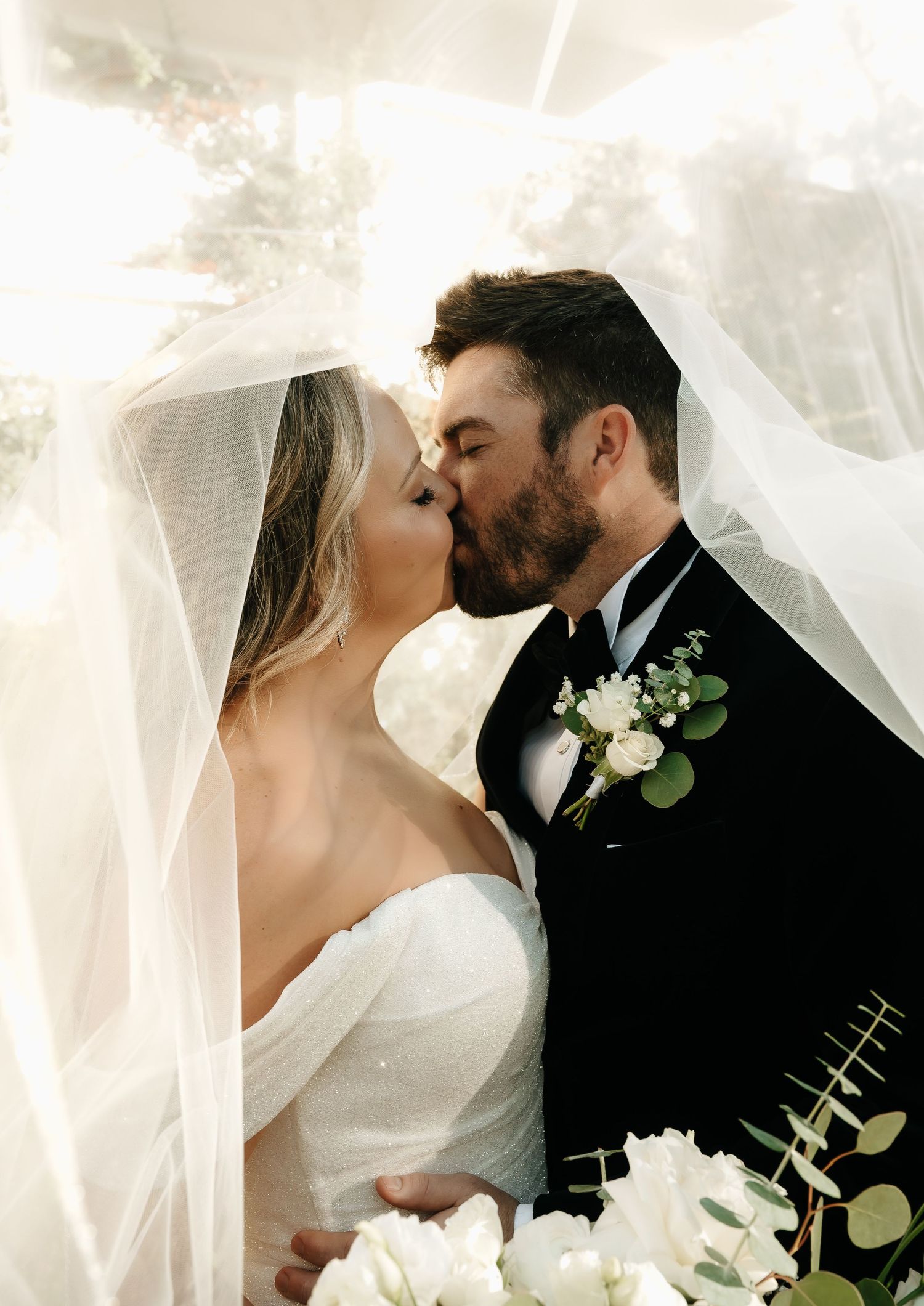 Ethereal wedding portraits with flowing veil and white floral boutonniere.
