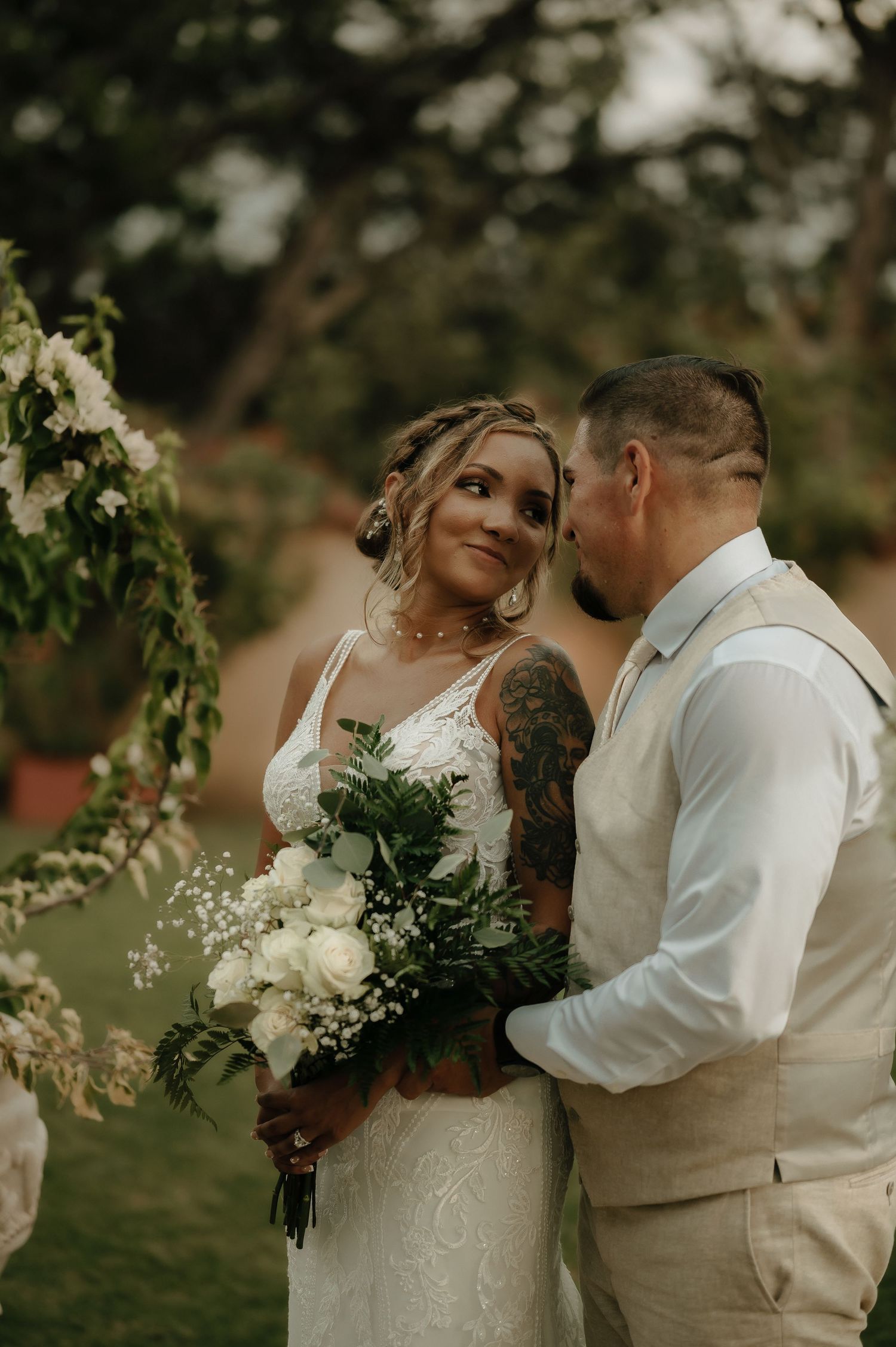 Romantic outdoor wedding portraits with natural greenery and white floral bouquets.