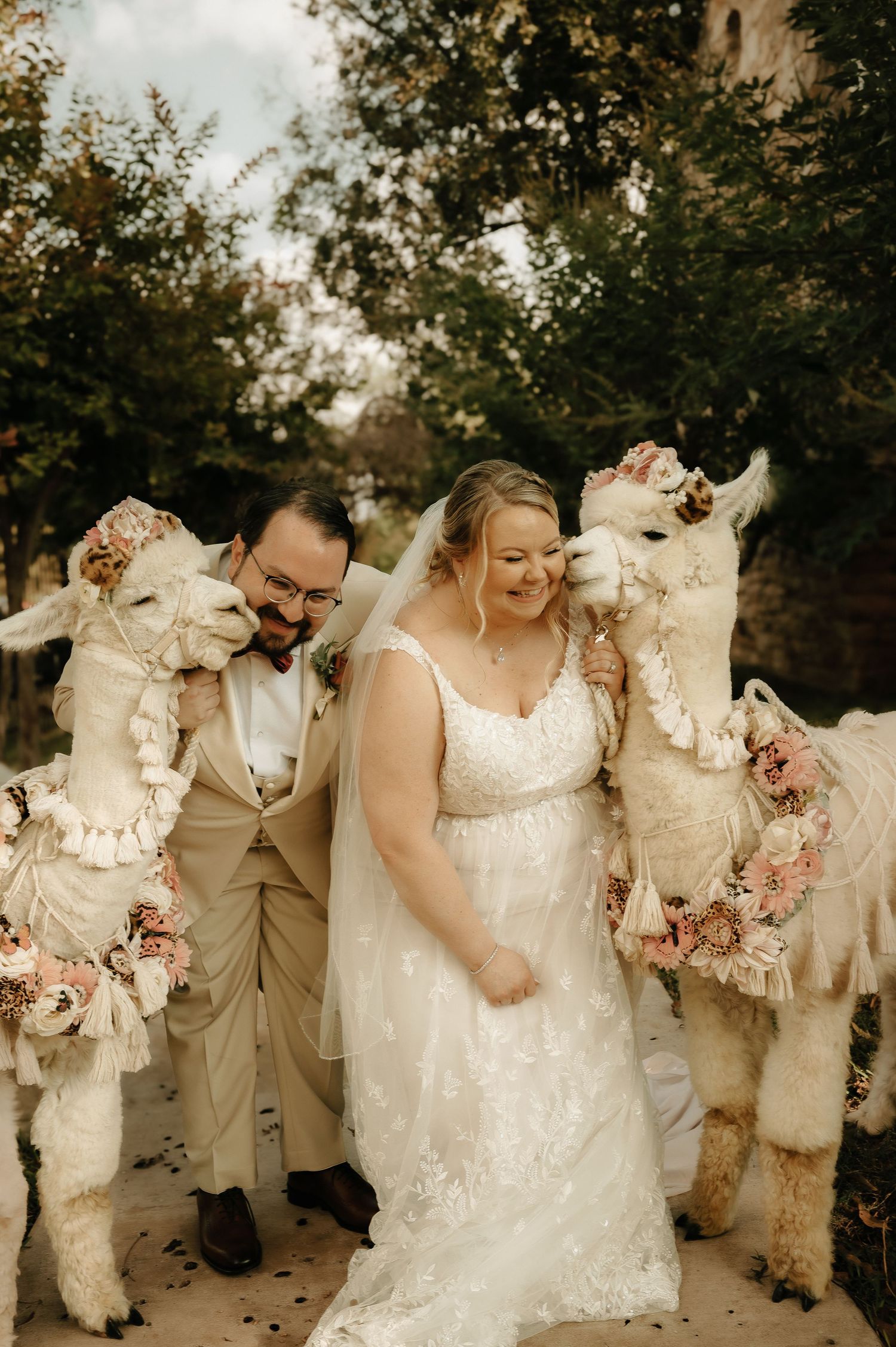 Wedding party wearing white and beige attire poses together in a candid outdoor celebration moment.