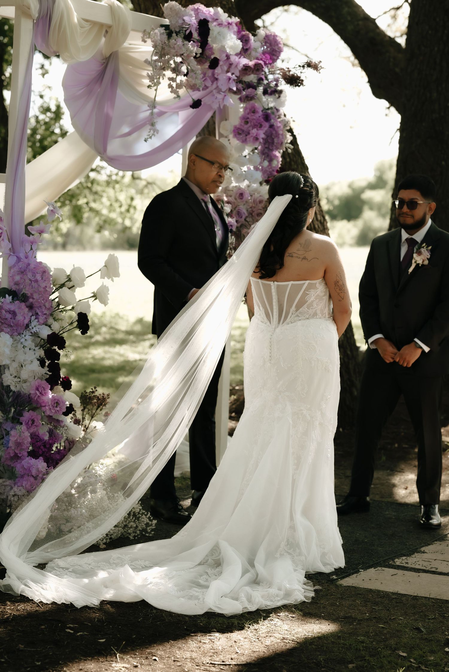 Elegant white wedding dress with flowing train photographed in natural outdoor lighting.