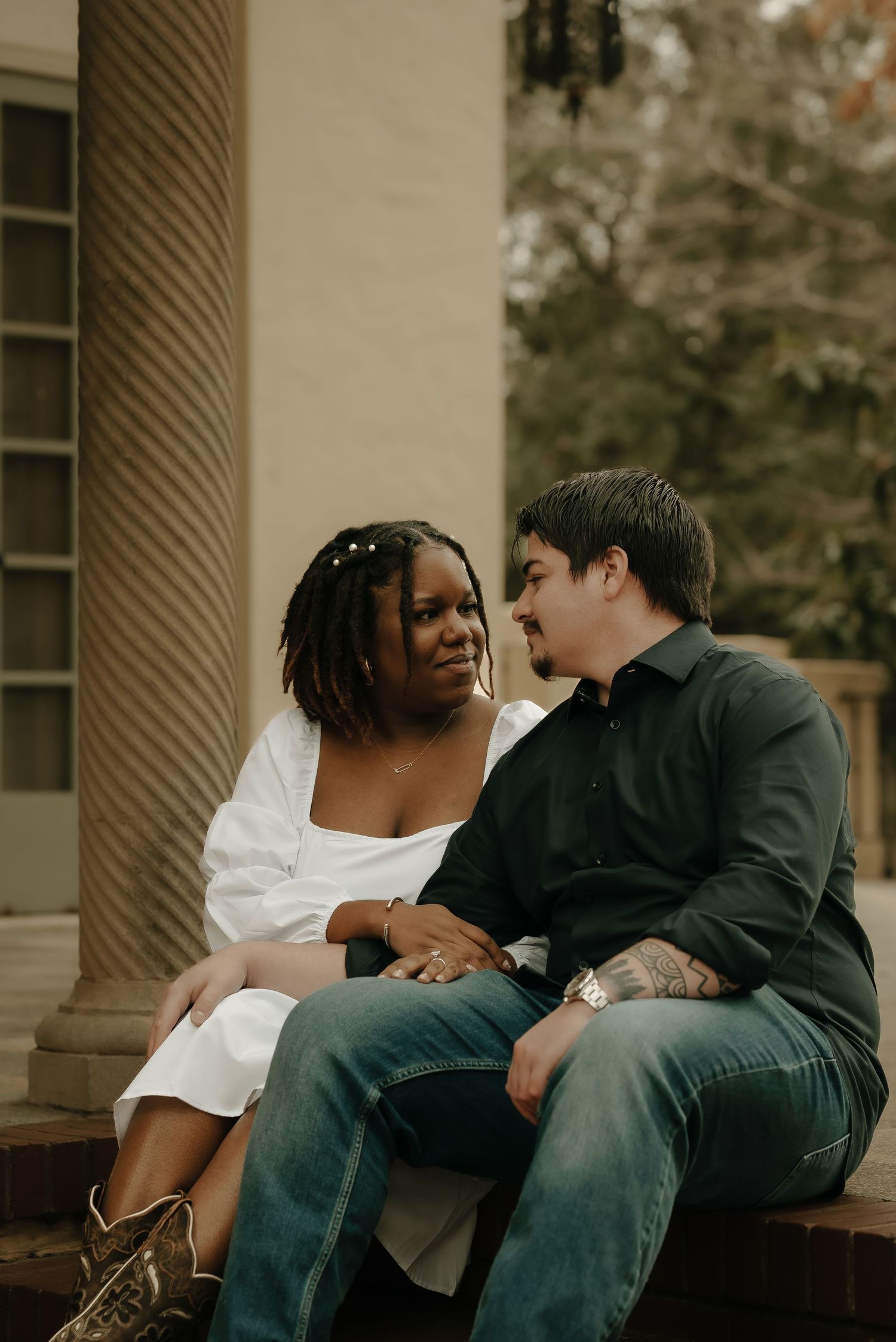 Couple sharing an intimate moment while sitting on outdoor steps.