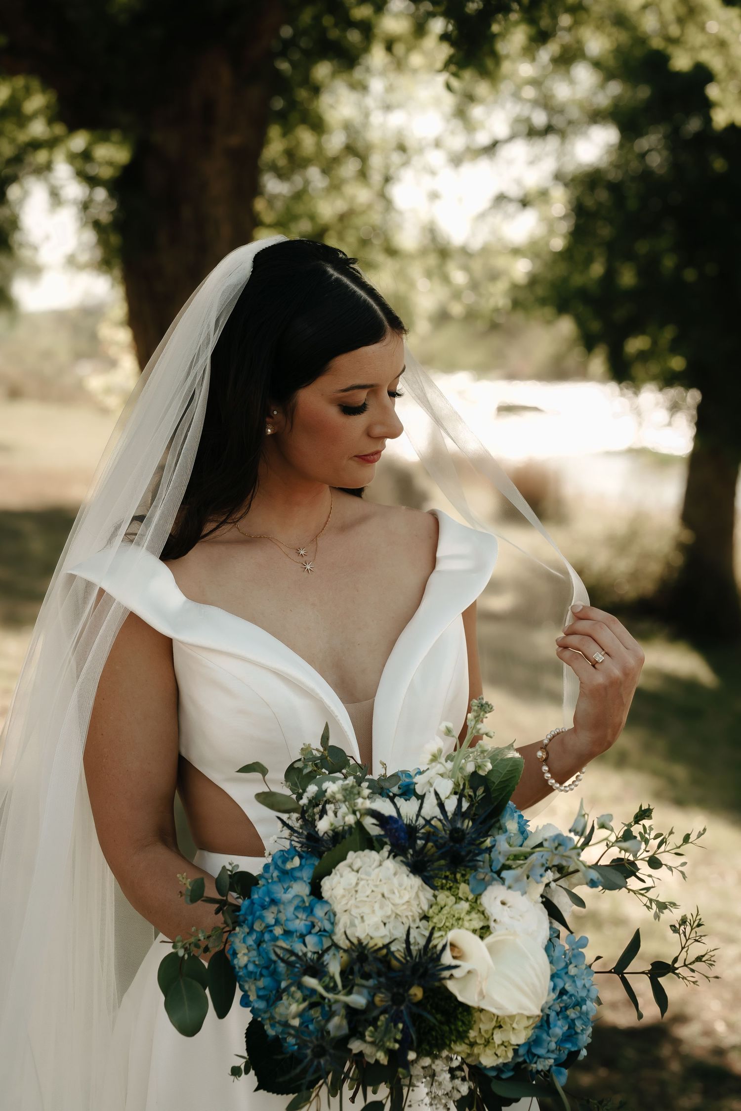 Bridal bouquet features stunning blue hydrangeas and white flowers with greenery.